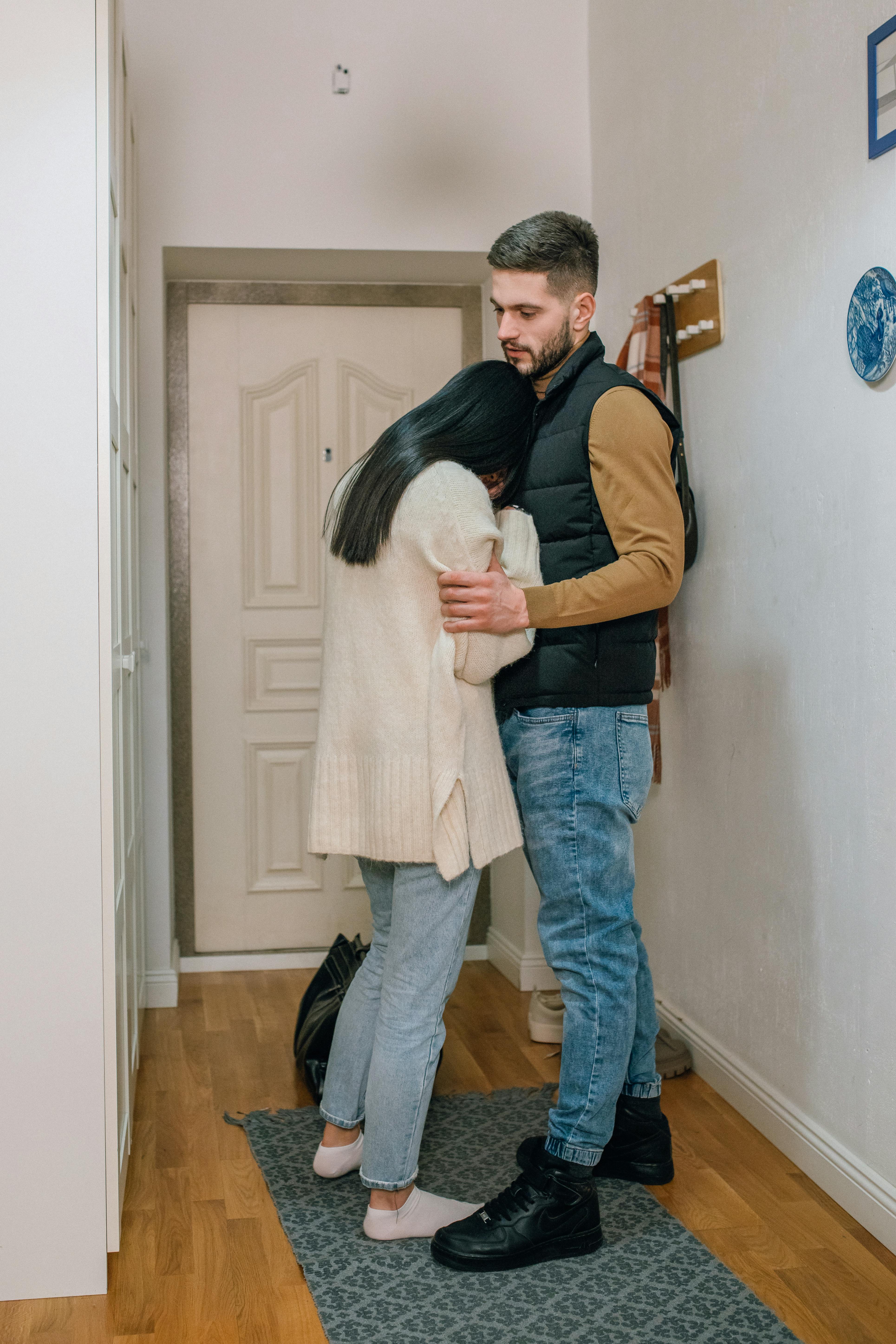 A man consoling an upset woman at the front door | Source: Pexels