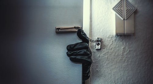 A burglar breaking into a home. | Source: Shutterstock.