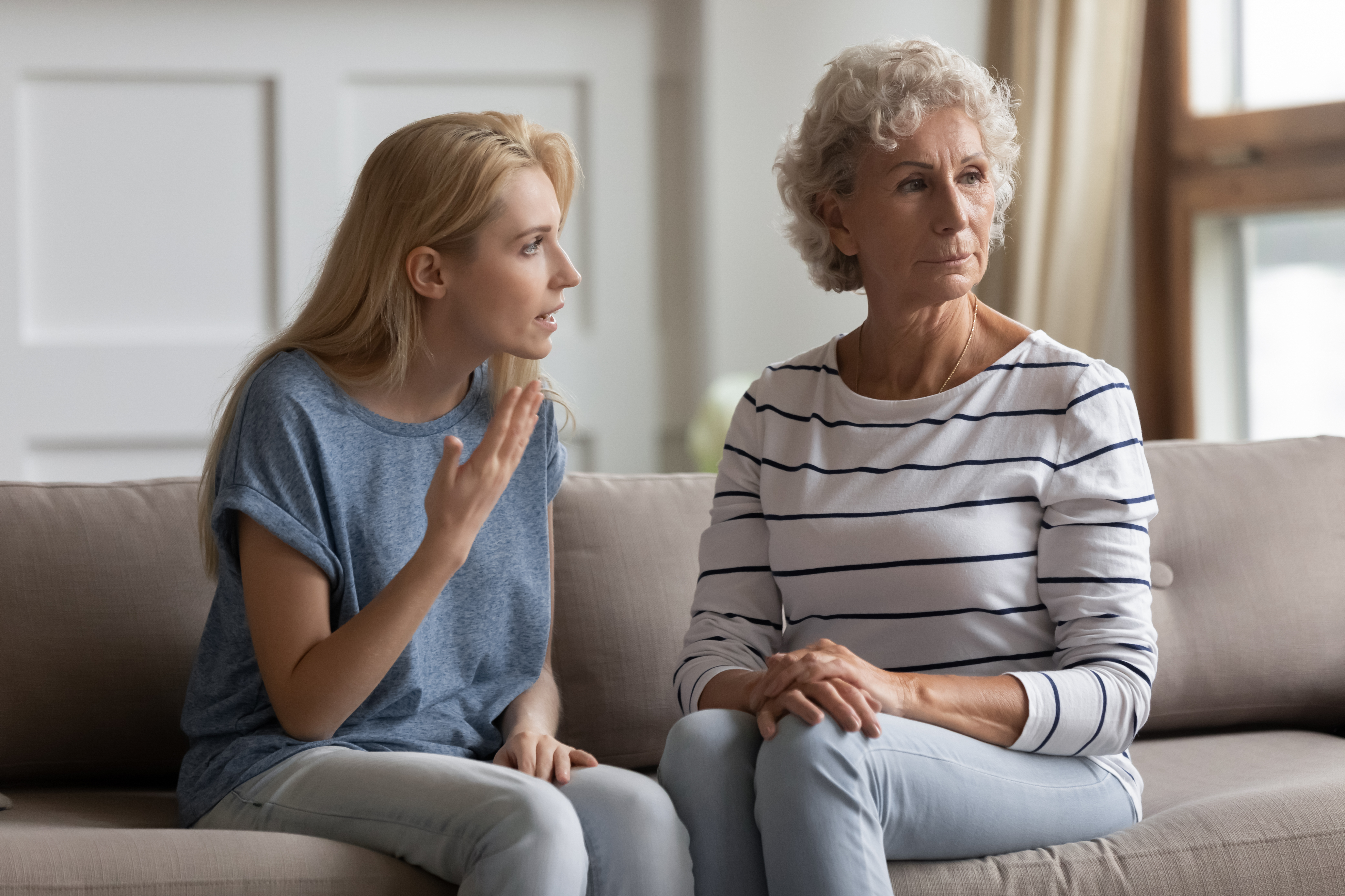 Young woman talking to an older woman who is looking away | Source: Shutterstock