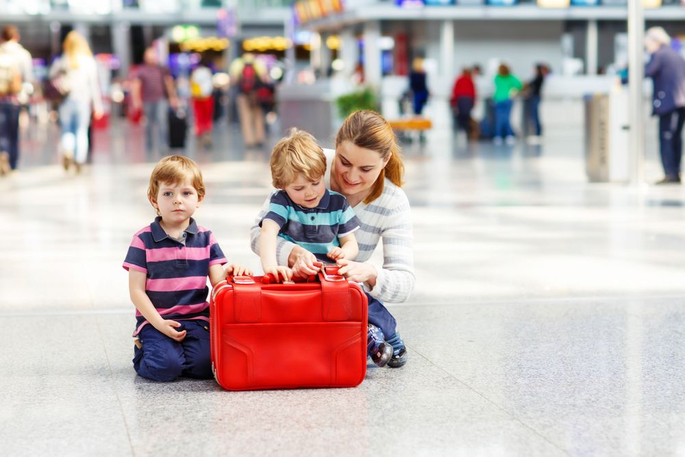 A woman with two kids sitting on the floor | Source: Shutterstock