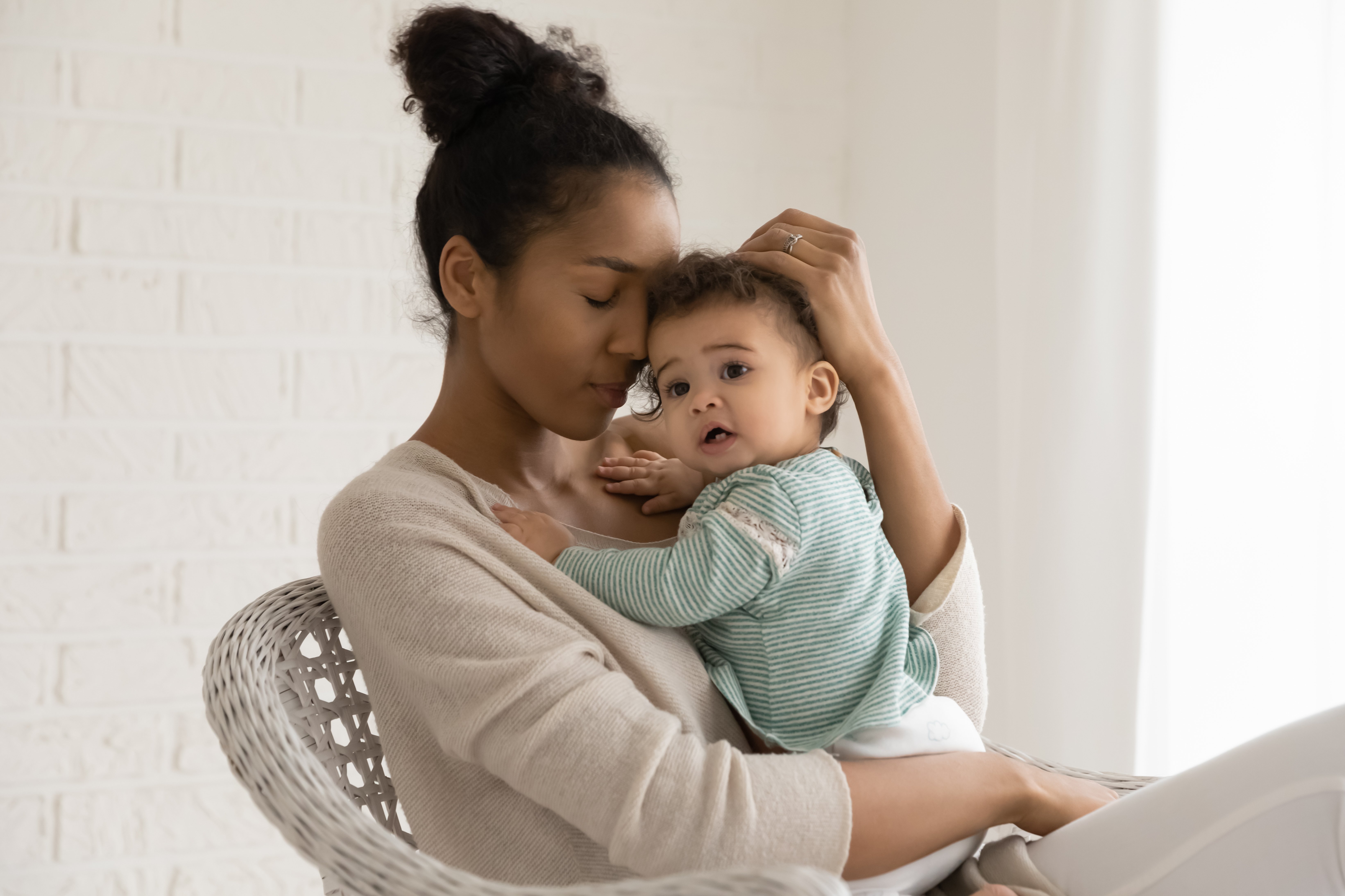 Une femme tenant son bébé dans son bras. | Photo : Shutterstock