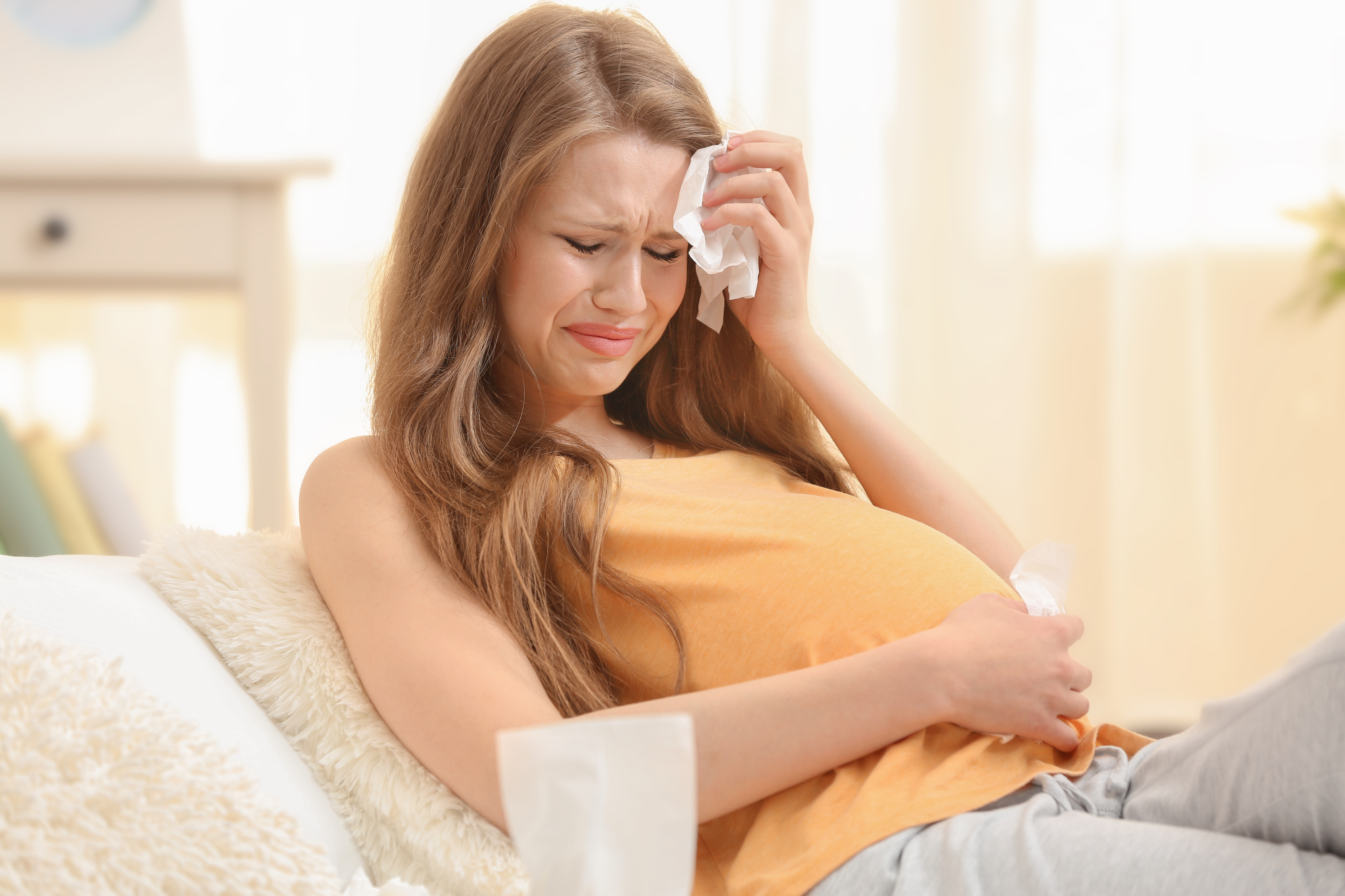 A pregnant woman crying | Source: Shutterstock