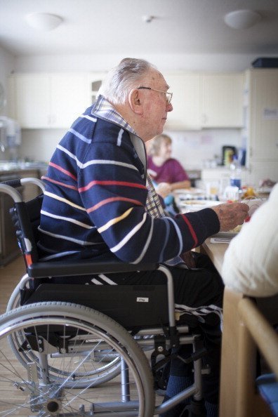  An old man sitting in his wheelchair eating lunch at a nursing home on the island of Borkum | Photo: Getty Images
