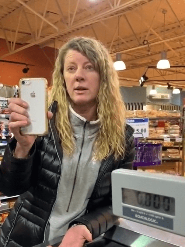 Blonde lady in supermarket holding up a phone to record a video. │Source: Reddit/PublicFreakout