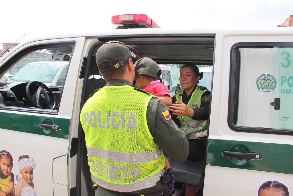 Oficial de policía sostiene a bebé en sus brazos para entregarlo a mujer. | Foto Archivo: Flickr Oficial de policía sostiene a bebé en sus brazos para entregarlo a mujer. | Foto Archivo: Flickr