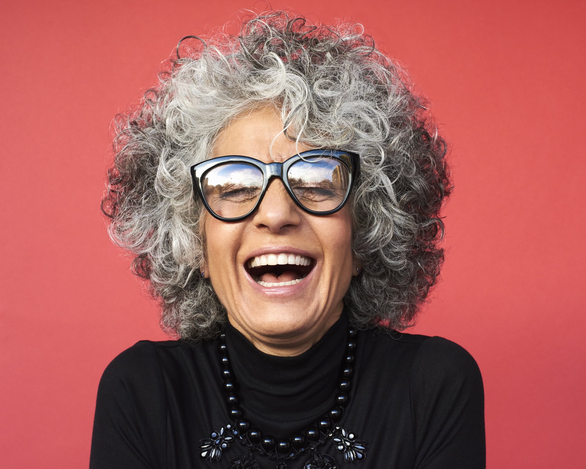 Une femme en lunettes entrain de rire. | Photo : Getty Images