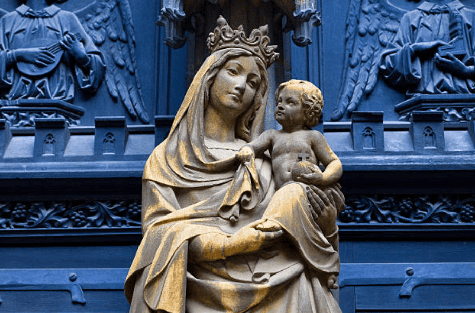 Une statue en pierre historique de la Vierge Marie tenant un bébé Jésus. Il reste en dehors de l'église dominicaine à Colmar, Alsace, France | Source: Getty Images