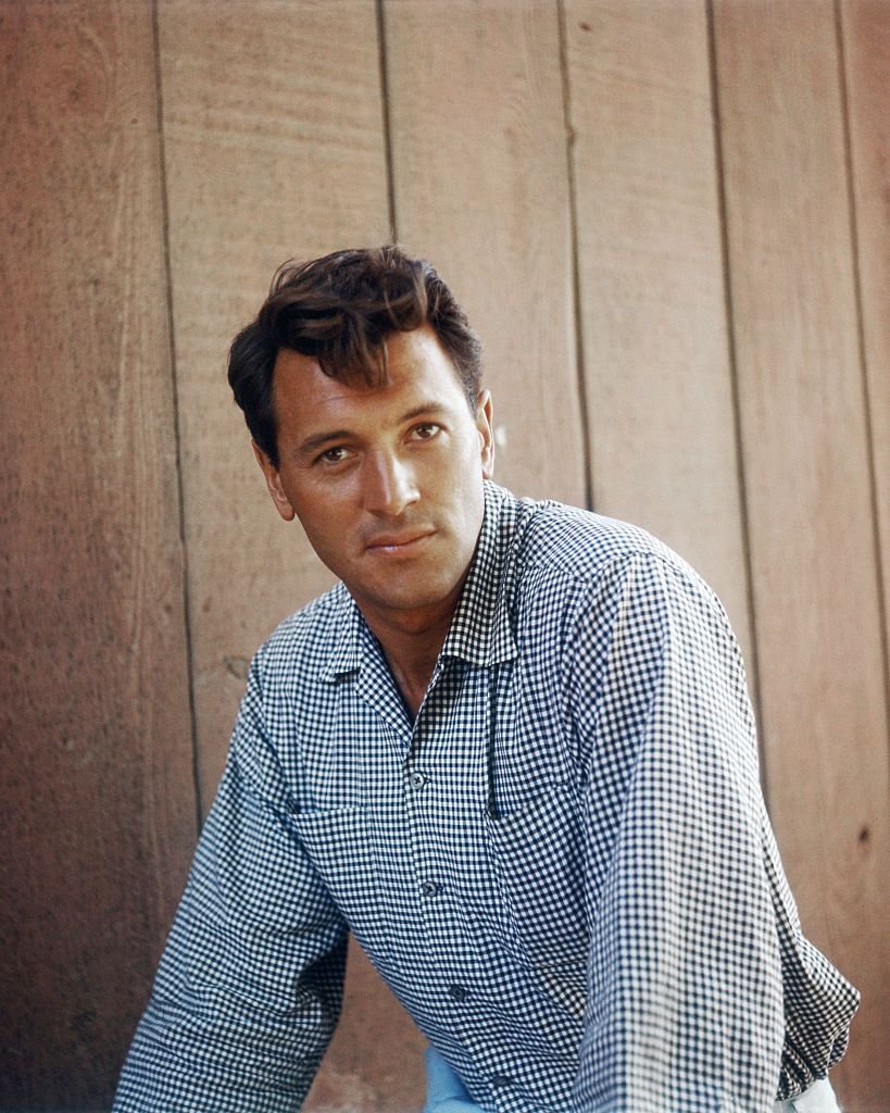A portrait of Rock Hudson against a wooden backdrop on 01 January, 1960 | Photo: Getty Images