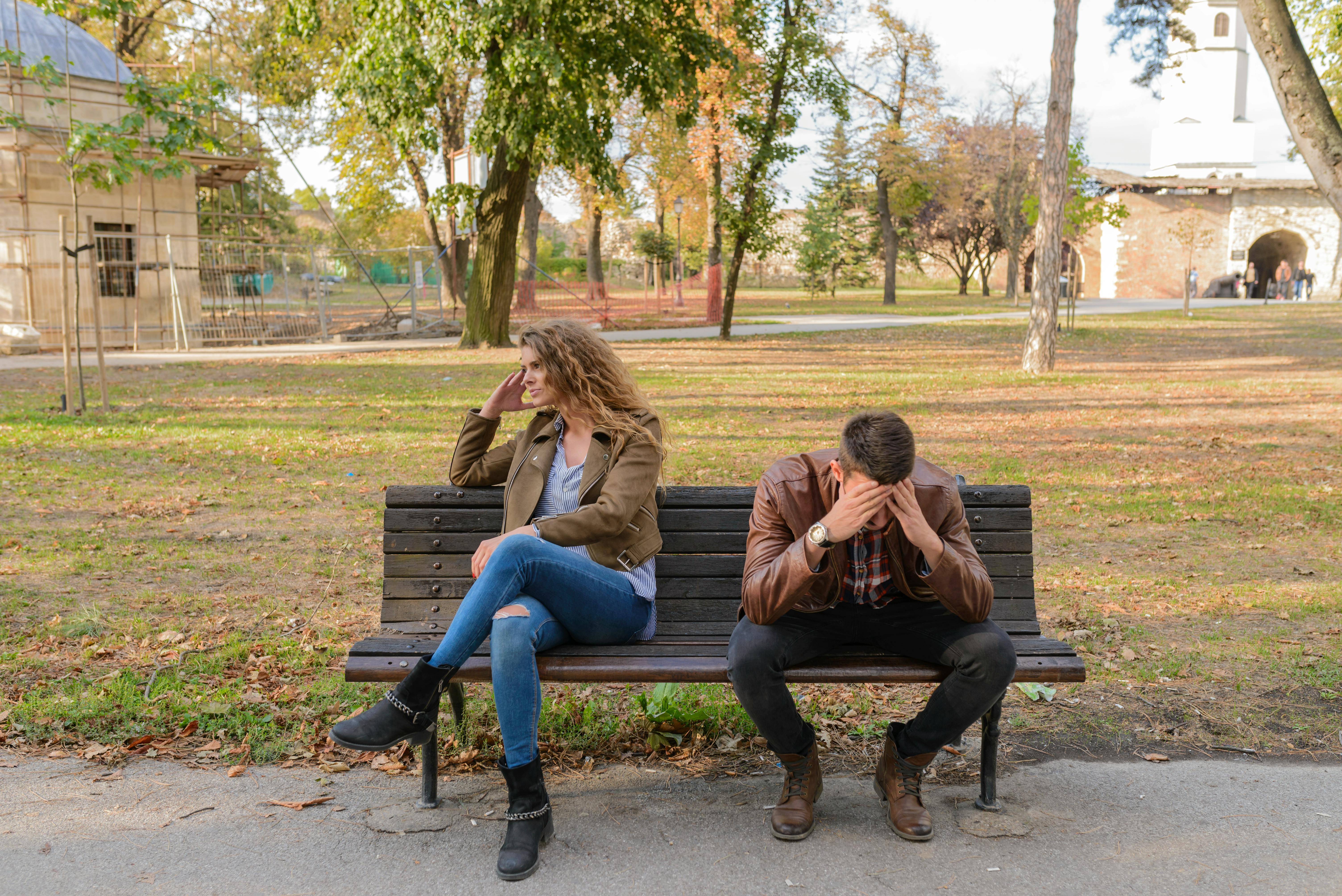 An unhappy couple sitting on a park bench | Source: Pexels