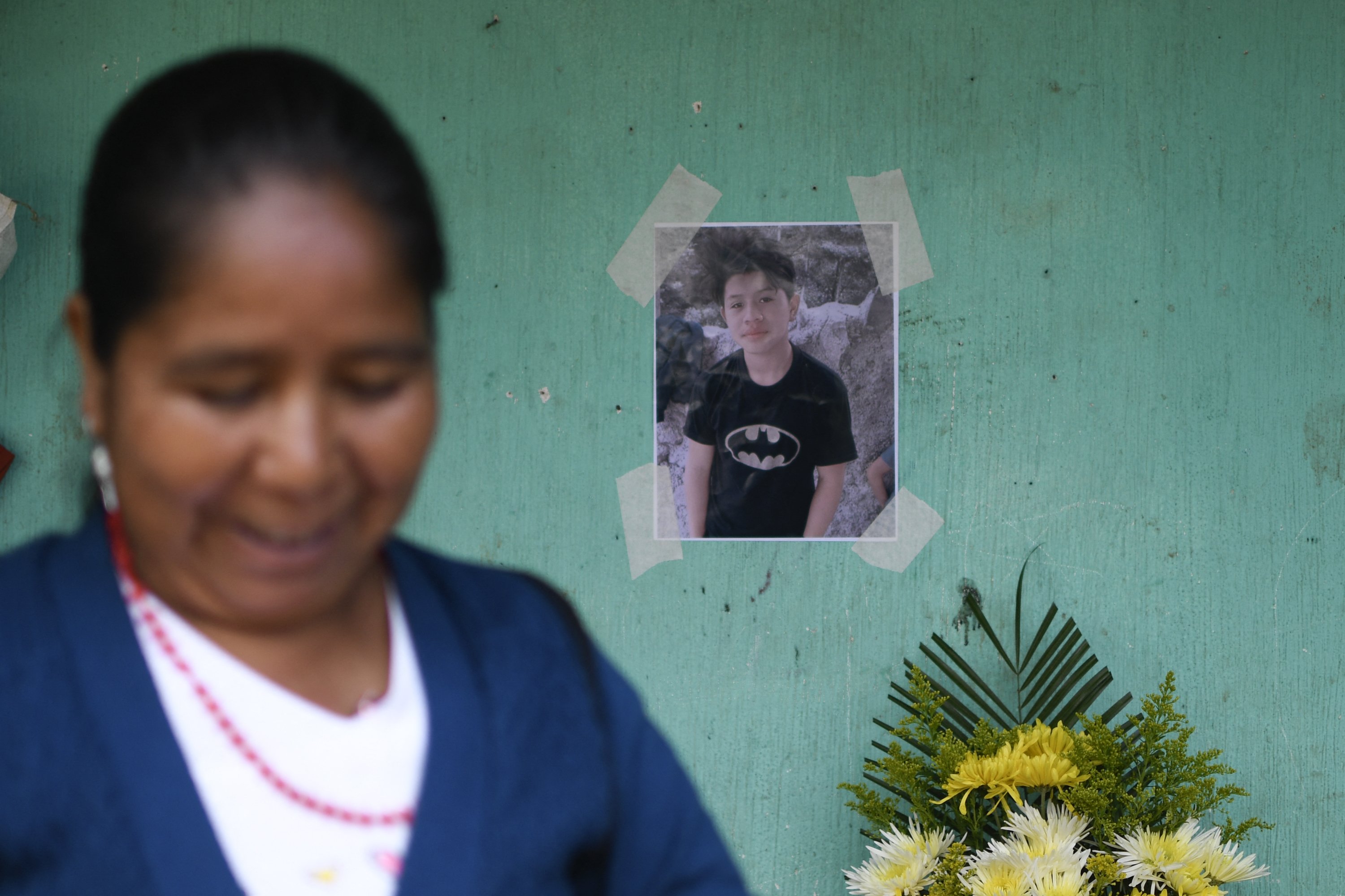 Der Verwandte von Juan Wilmer Tepaz mit einem Bild von Wilmer im Hintergrund in Guatemala im Jahr 2022. | Quelle: Getty Images