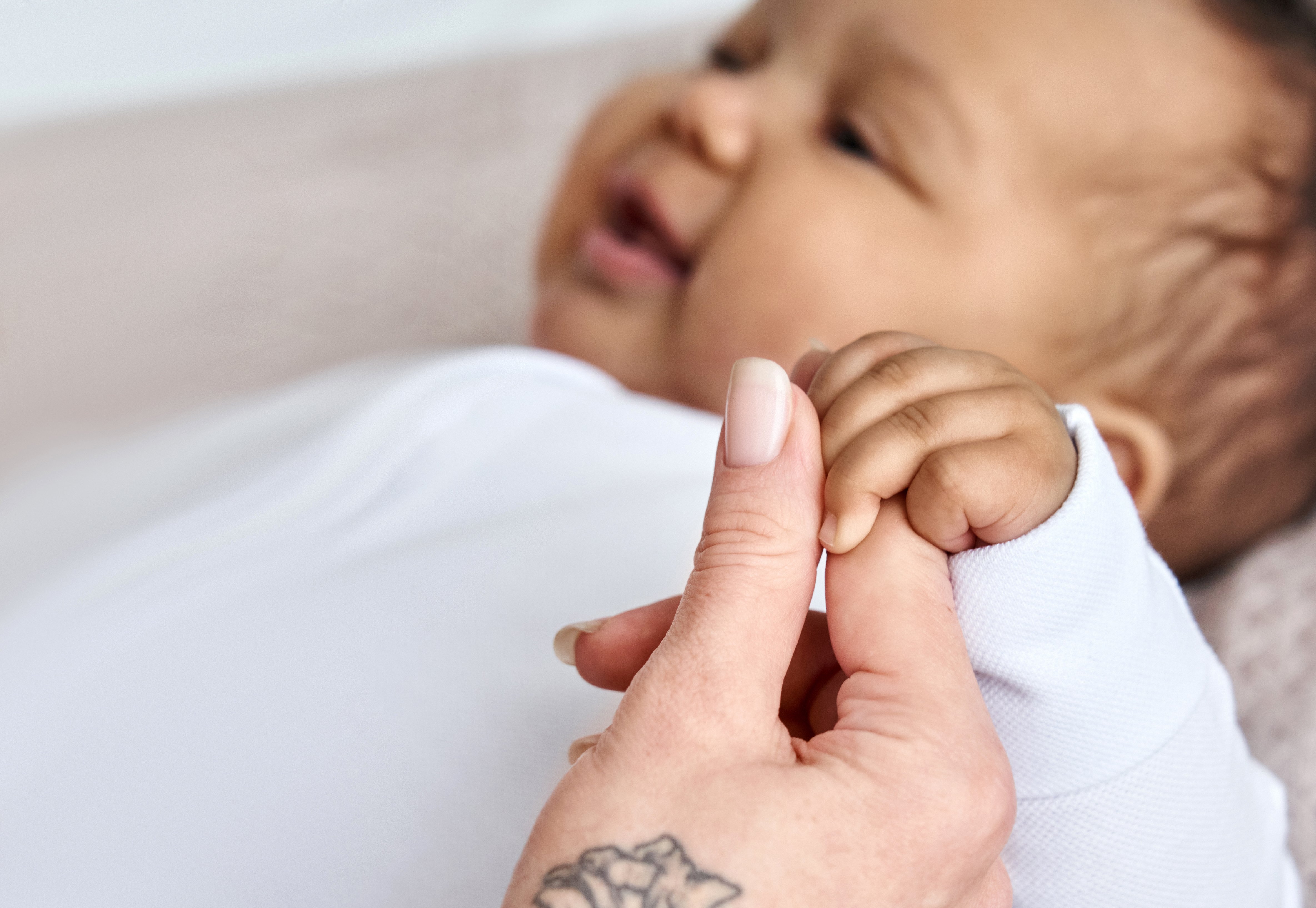 Bebé de raza mixta y mano de mujer blanca. | Foto: Shutterstock