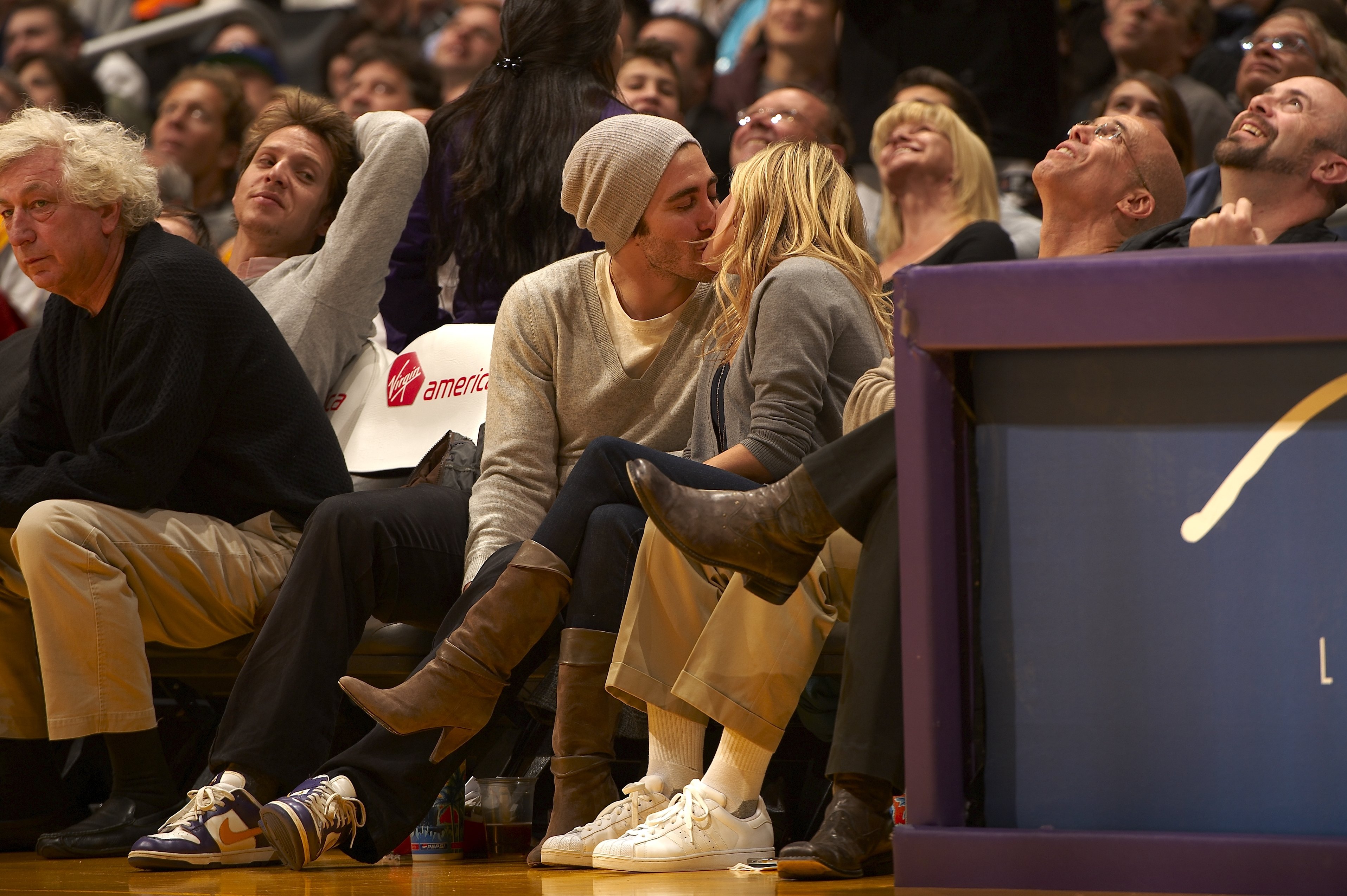 Gyllenhaal and Witherspoon share a kiss courtside during the Los Angeles Lakers vs. Portland Trail Blazers game on January 4, 2009, in Los Angeles, California. The couple looks completely in love, seemingly oblivious to the crowd around them.