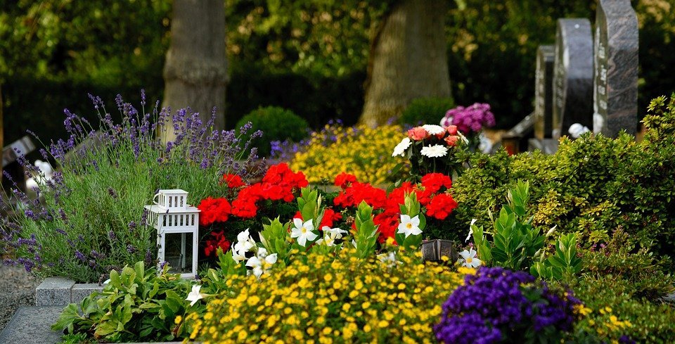 An arrangement of several flowers at the gravesite of someone at the cemetery. | Photo: Pixabay