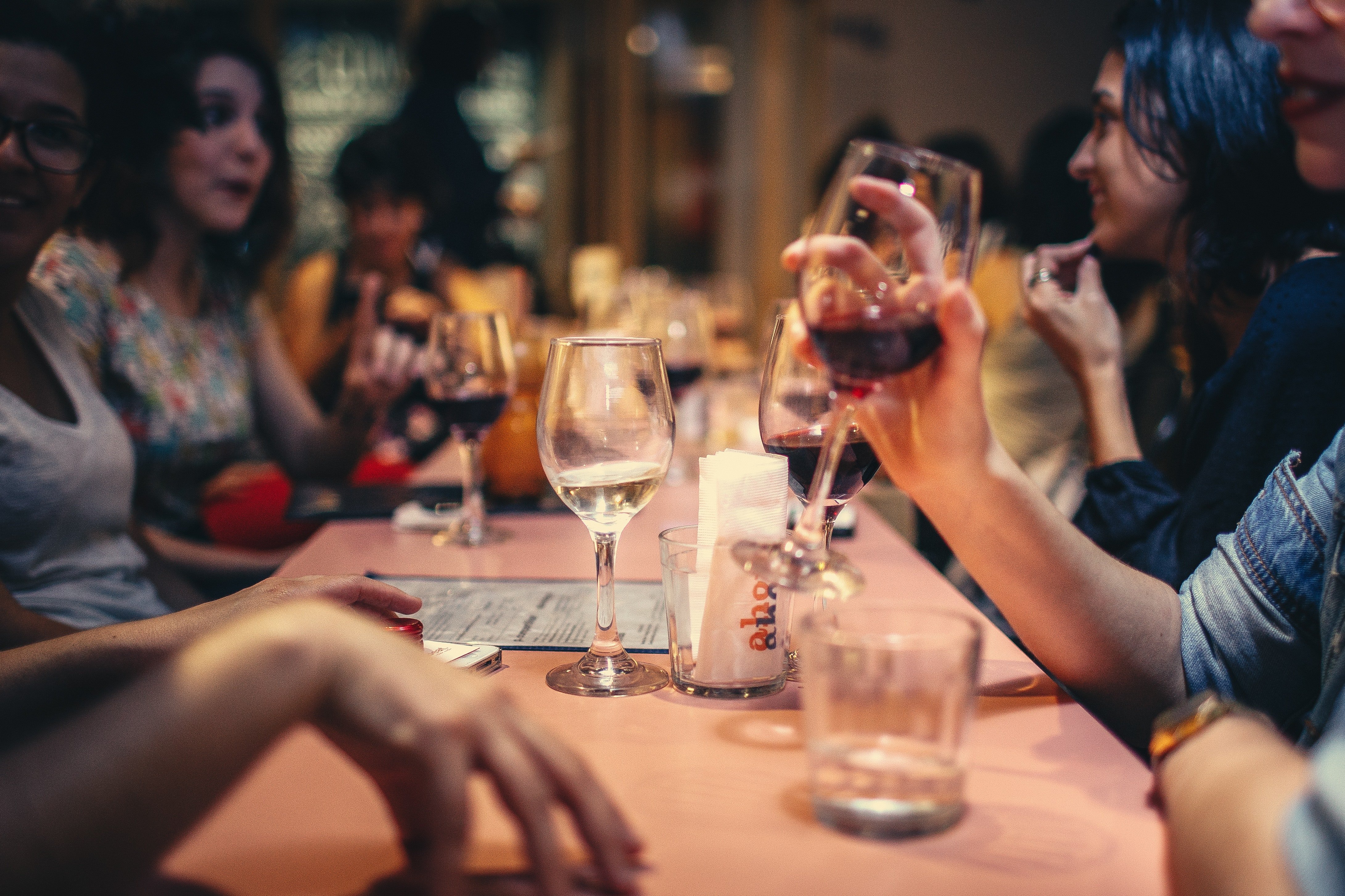 A table full of people and drinks. | Pexels/ Helena Lopes 
