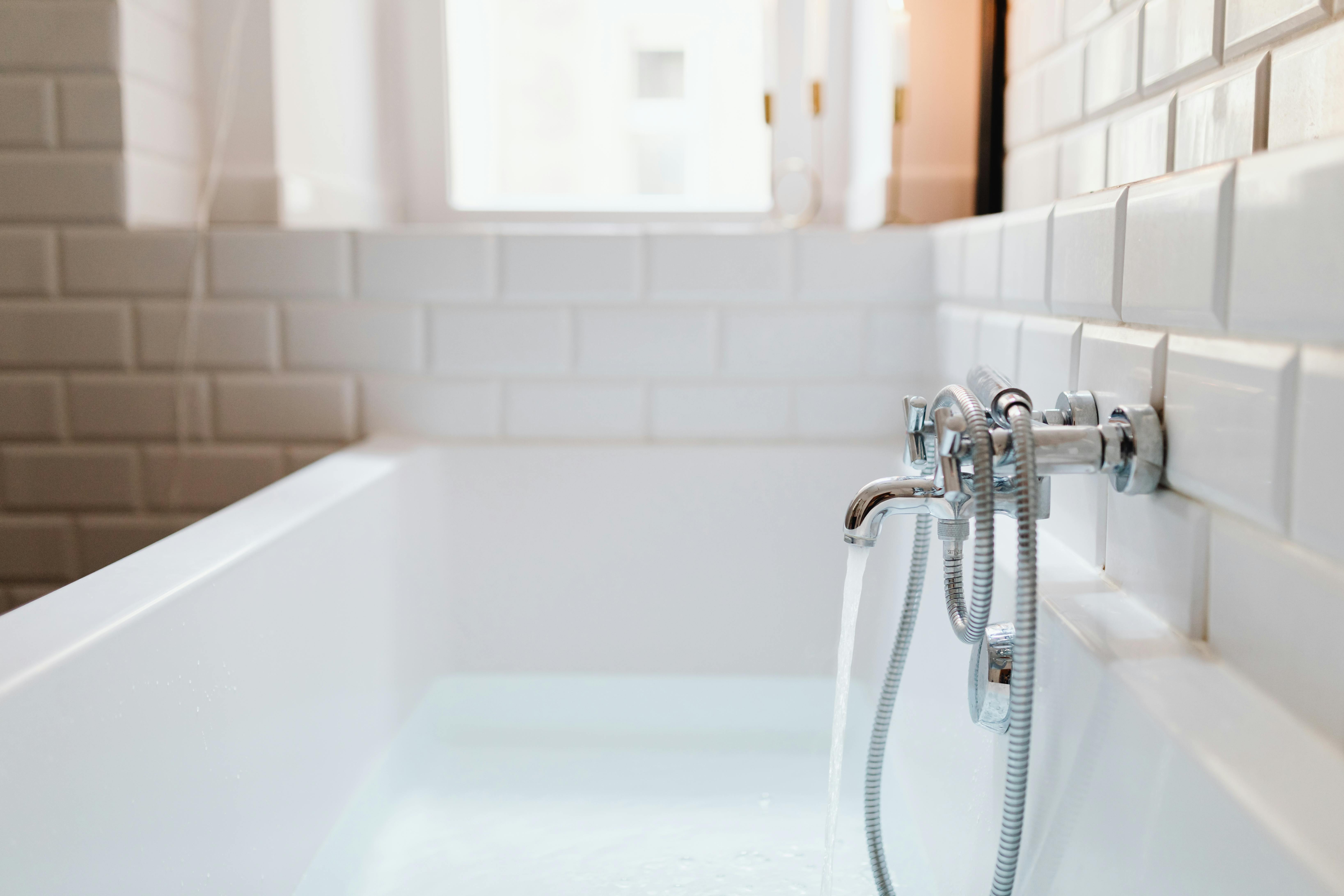 Metal bathroom fixtures for a tub | Source: Pexels