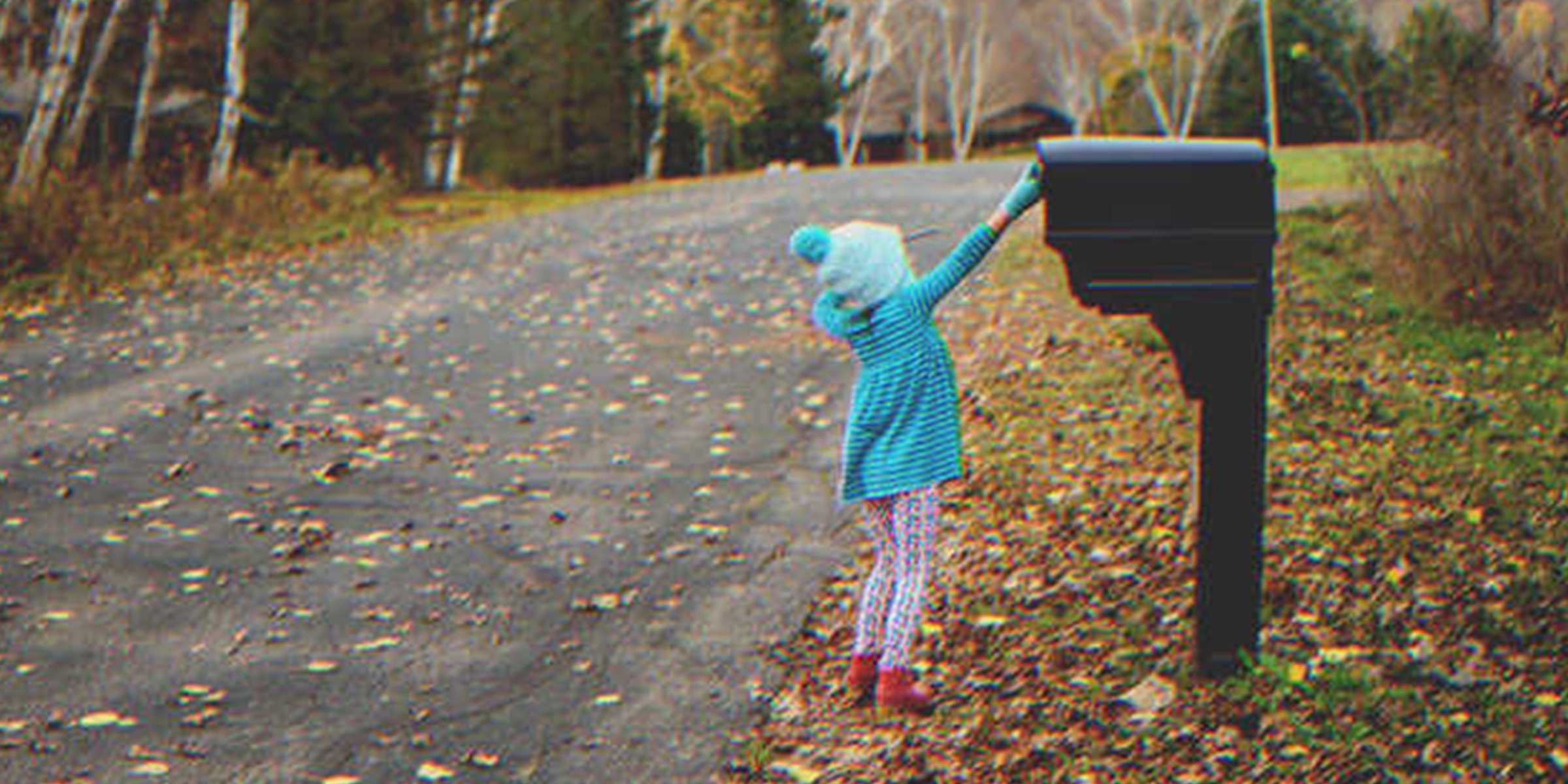 Little girl putting a letter into a mailbox | Source: Getty Images