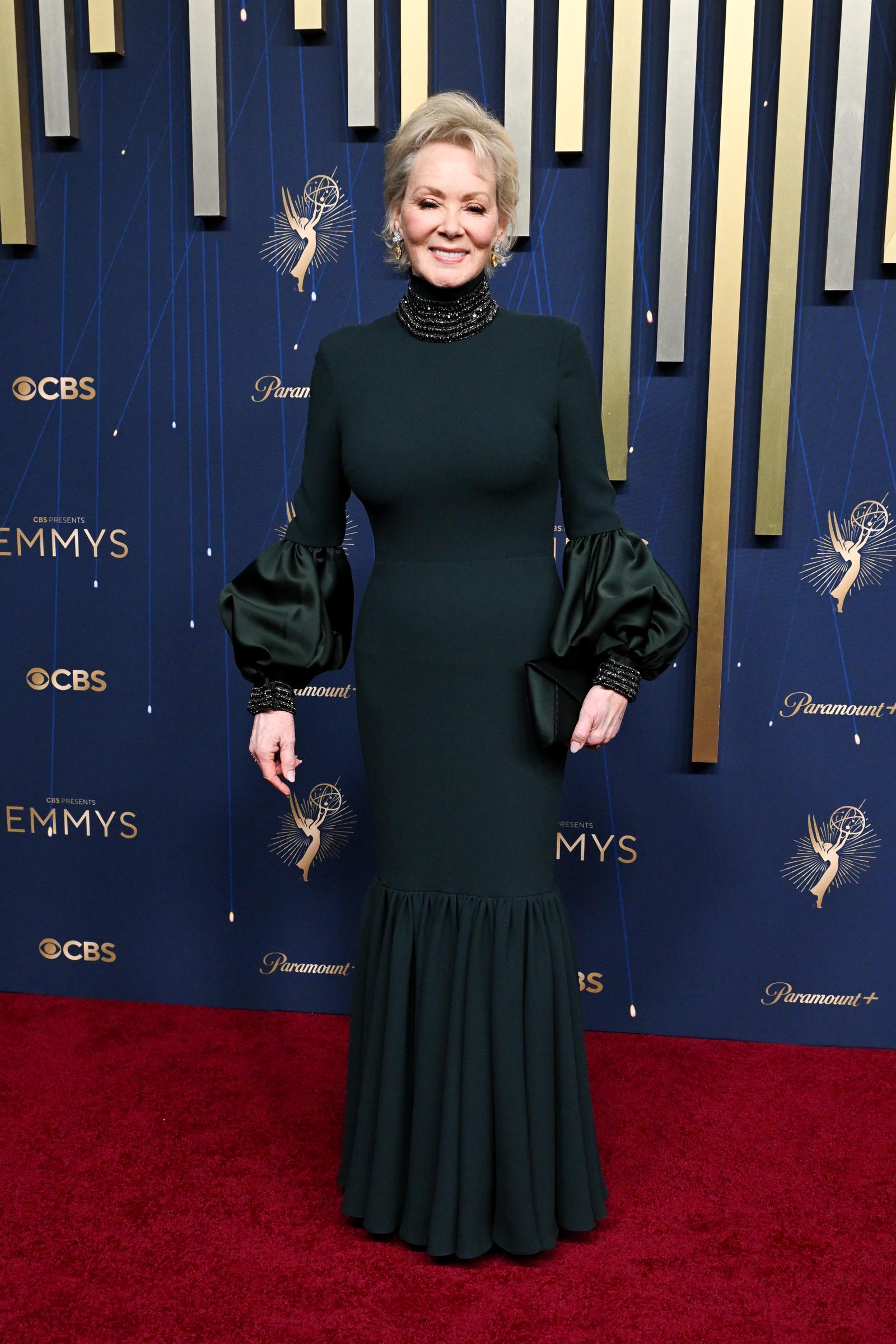 Jean Smart looks regal at the Emmys in a body-skimming forest green gown with puff sleeves and a high neck. Beaded accents at the neck and wrists add built-in drama to the look.