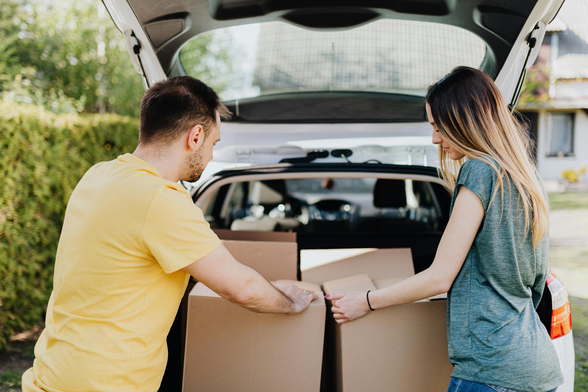 A couple unloading boxes from their car | Source: Pexels