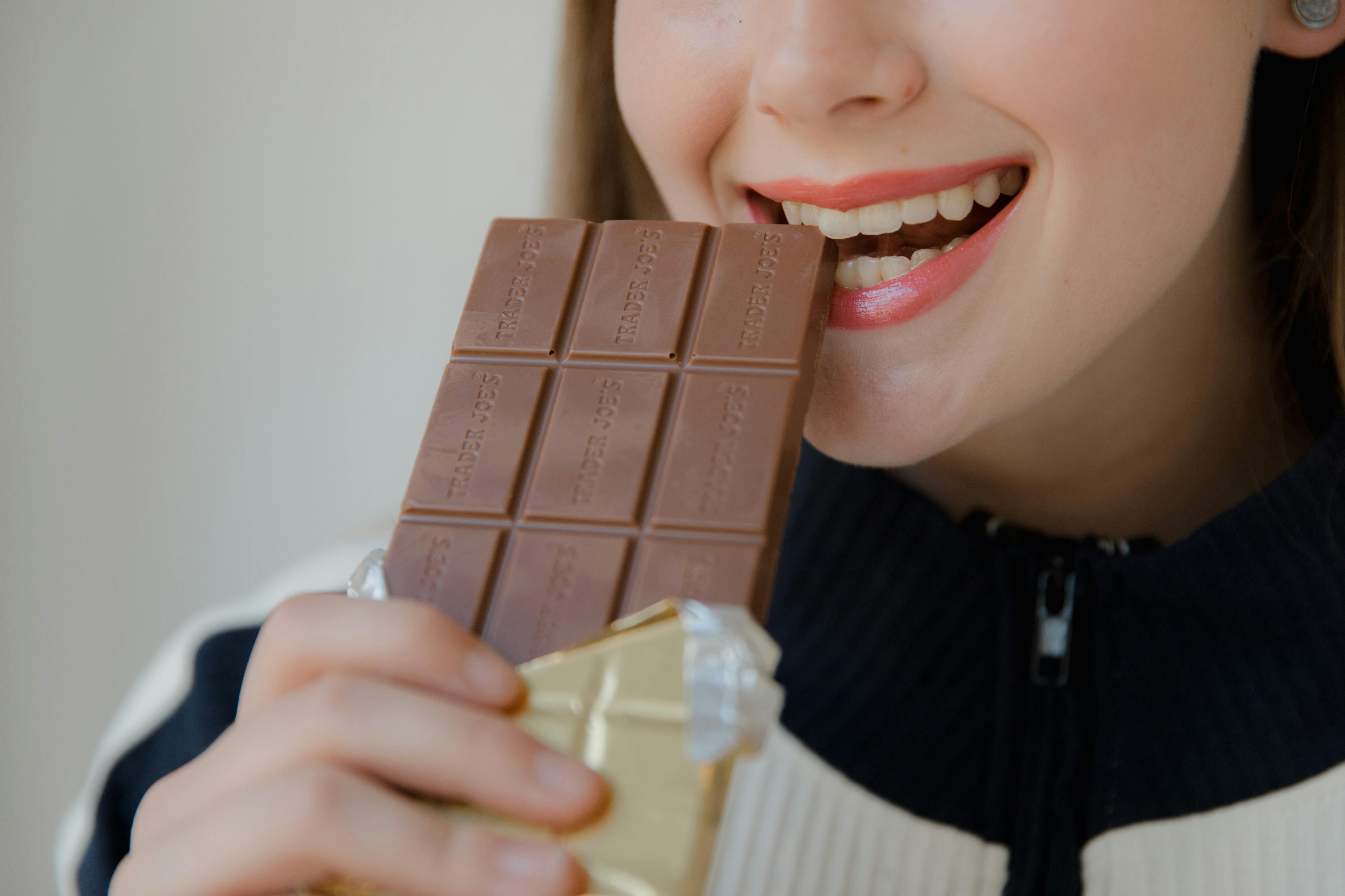 A woman eating a bar of chocolate | Source: Pexels