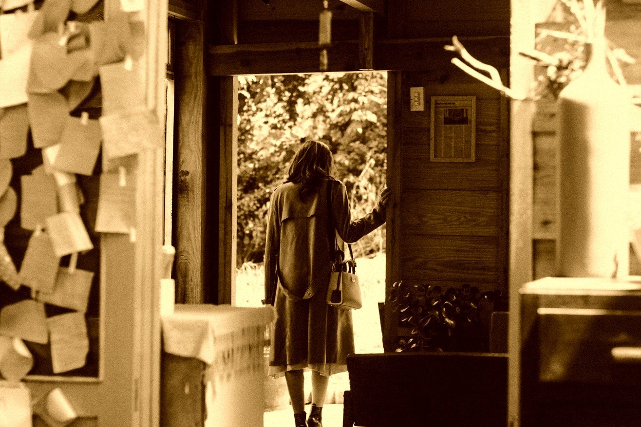 Una joven mujer sale por la puerta de su casa. | Foto: Pexels