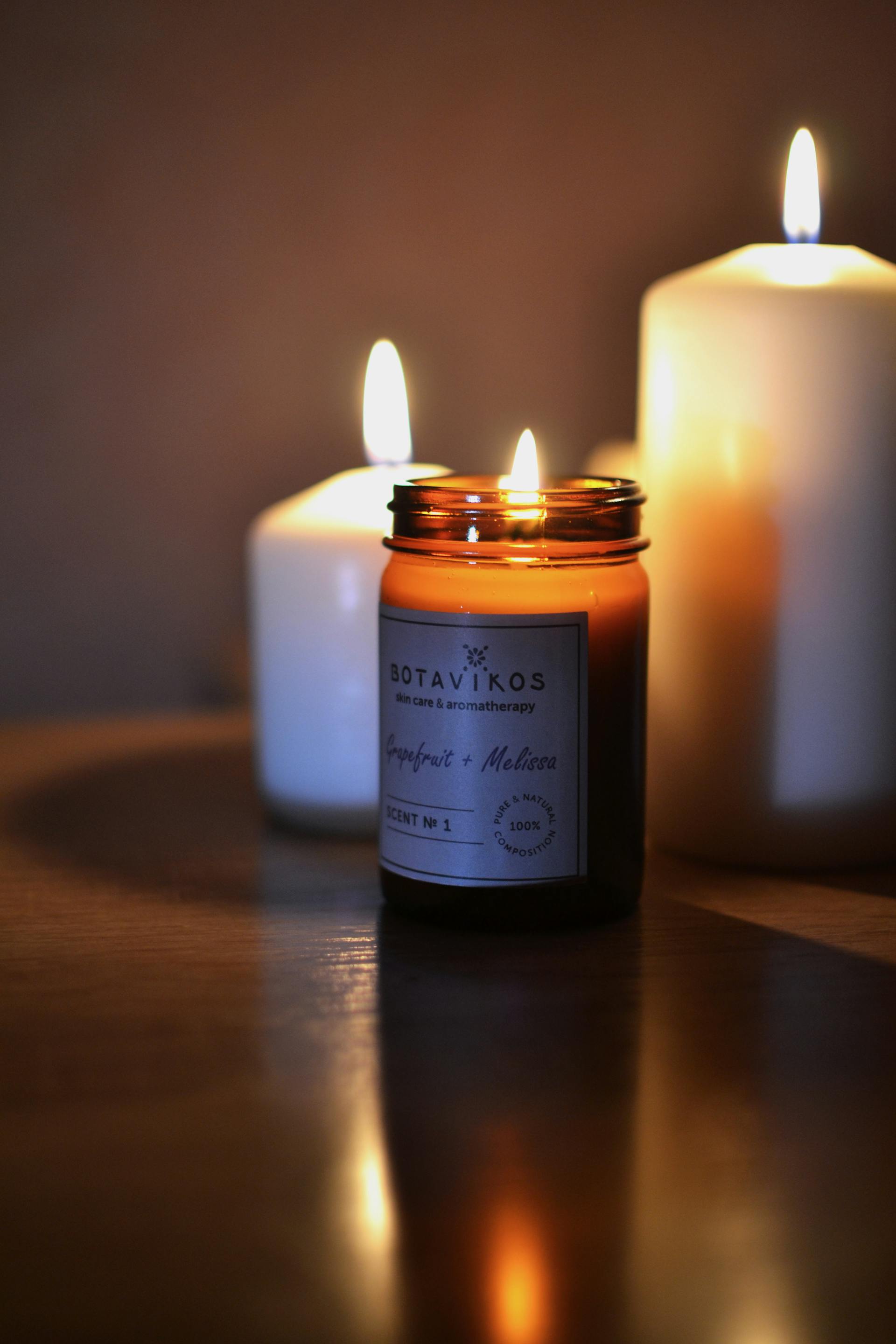 Scented candles placed on a wooden surface | Source: Pexels