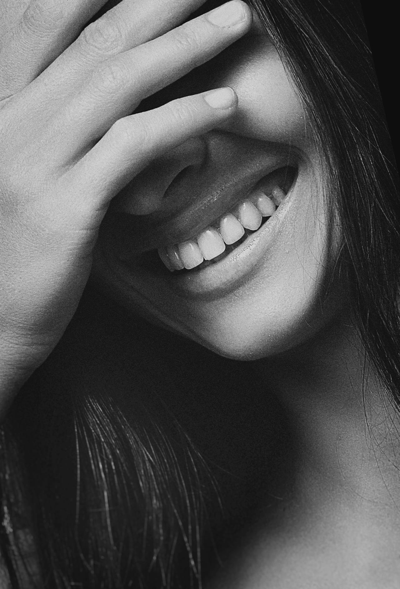 Grayscale shot of a young woman laughing | Source: Pexels