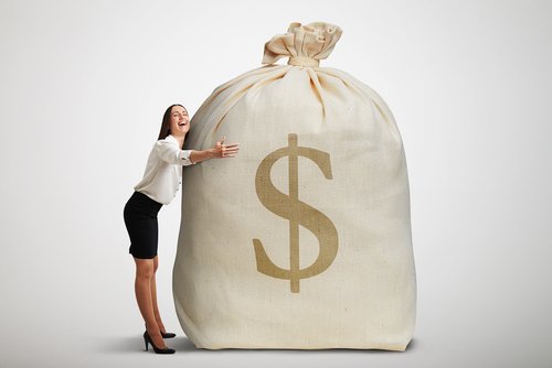 A woman smiling as she hugs a big bag of money. | Source: Shutterstock.
