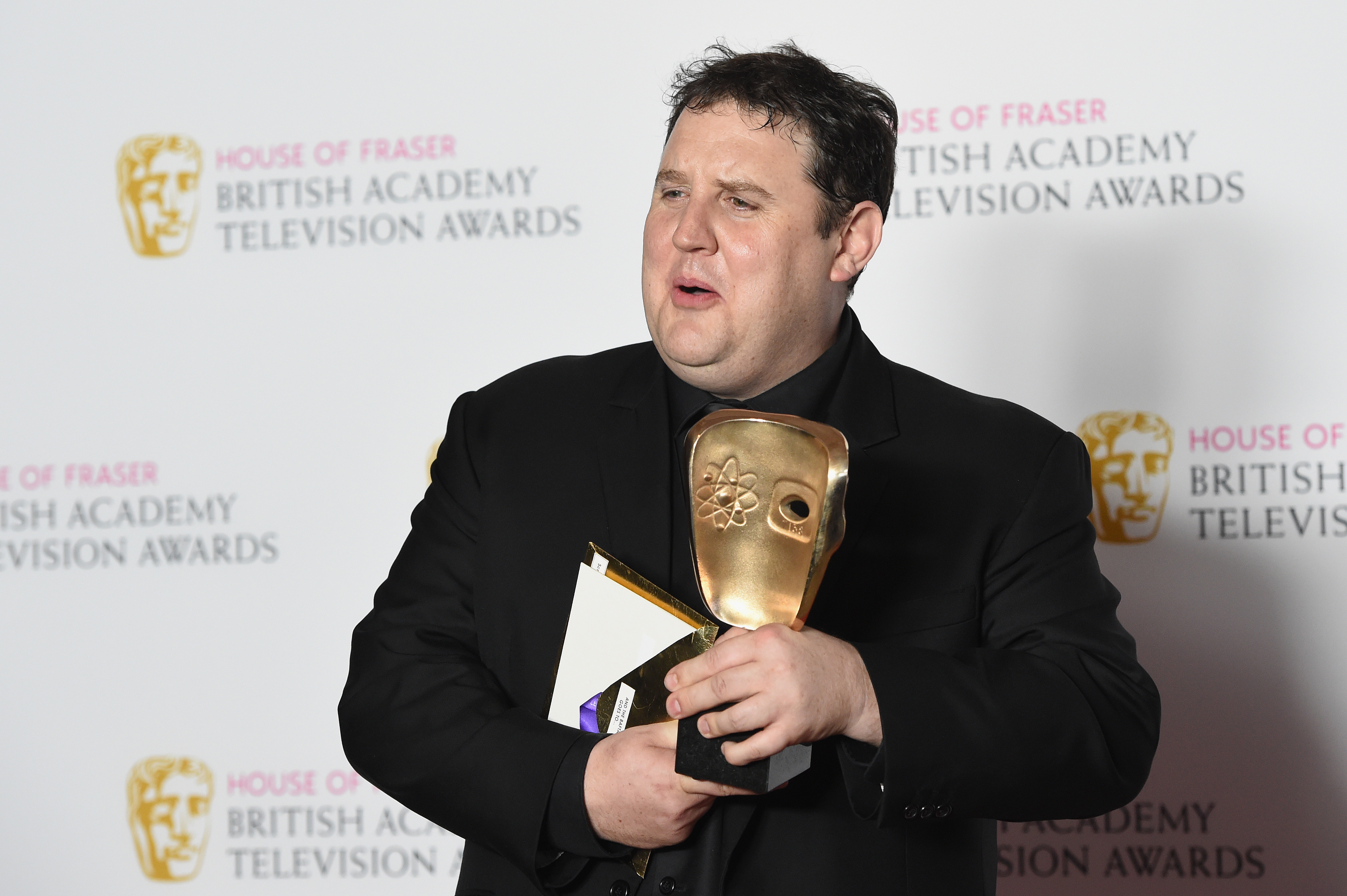 Peter Kay appeared noticeably fuller-faced as he posed backstage with his BAFTA at the 2016 House of Fraser British Academy Television Awards in London, where he won Male Performance in a Comedy Programme for "Peter Kay's Car Share." The image captured him at a time when his public persona was closely tied to his larger frame, years before his dramatic weight loss.