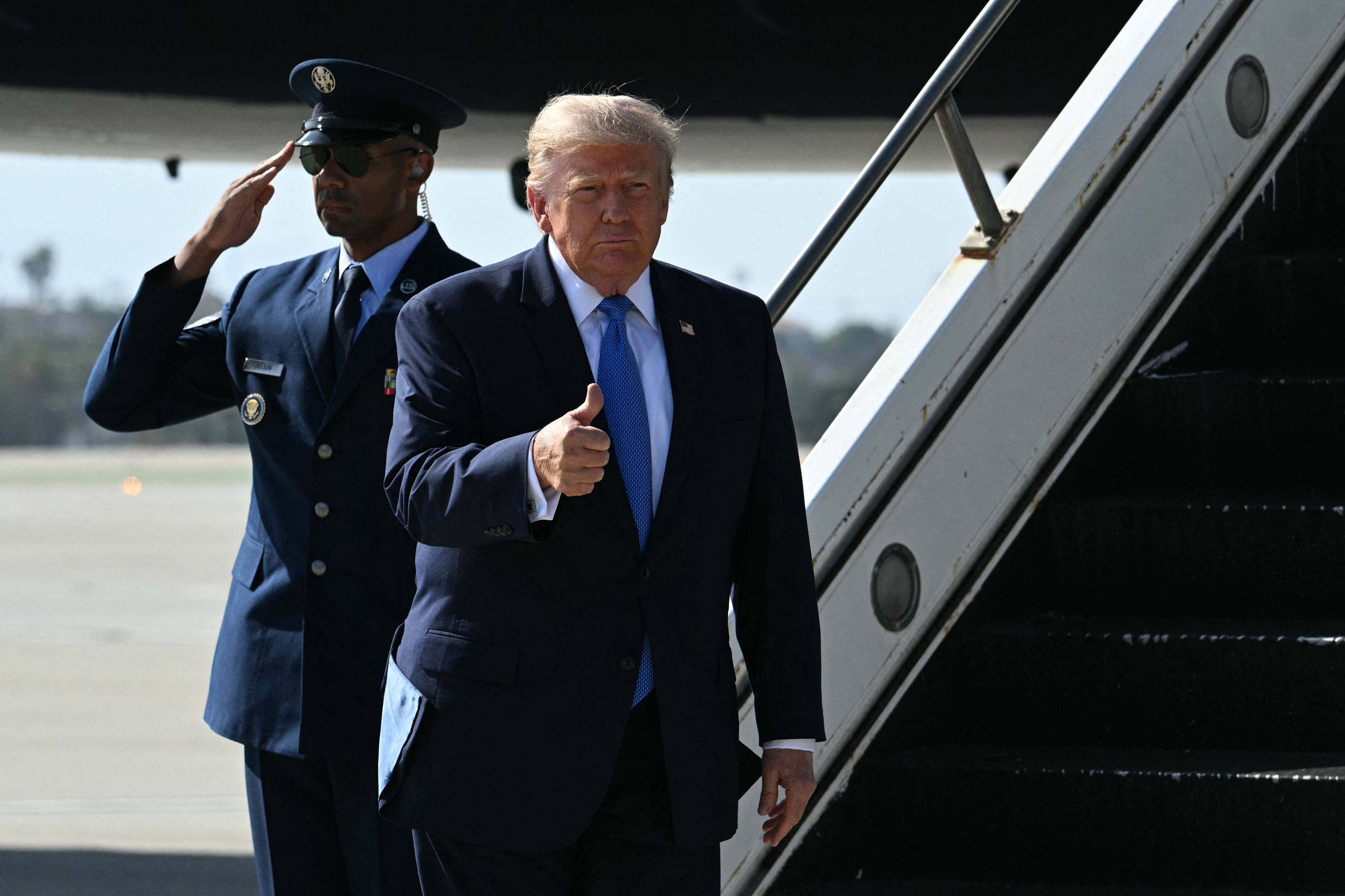 Trump gave a thumbs-up after stepping off Air Force One in Los Angeles, where his hair appeared flatter and more closely swept back than it did the following day in Las Vegas. | Source: Getty Images