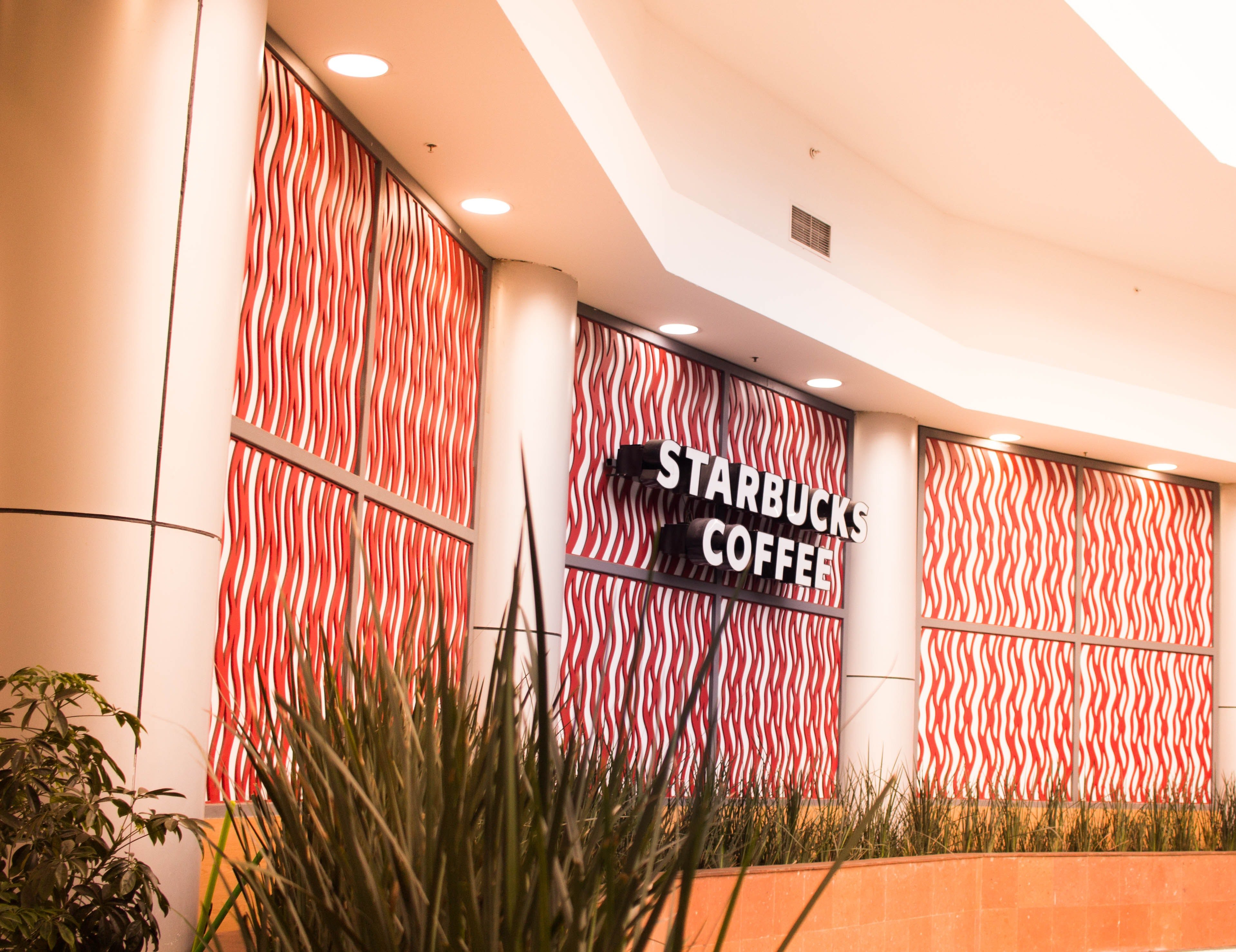 Starbucks branding can be seen on the side of one of their coffee shops | Photo: Pexels/David López 