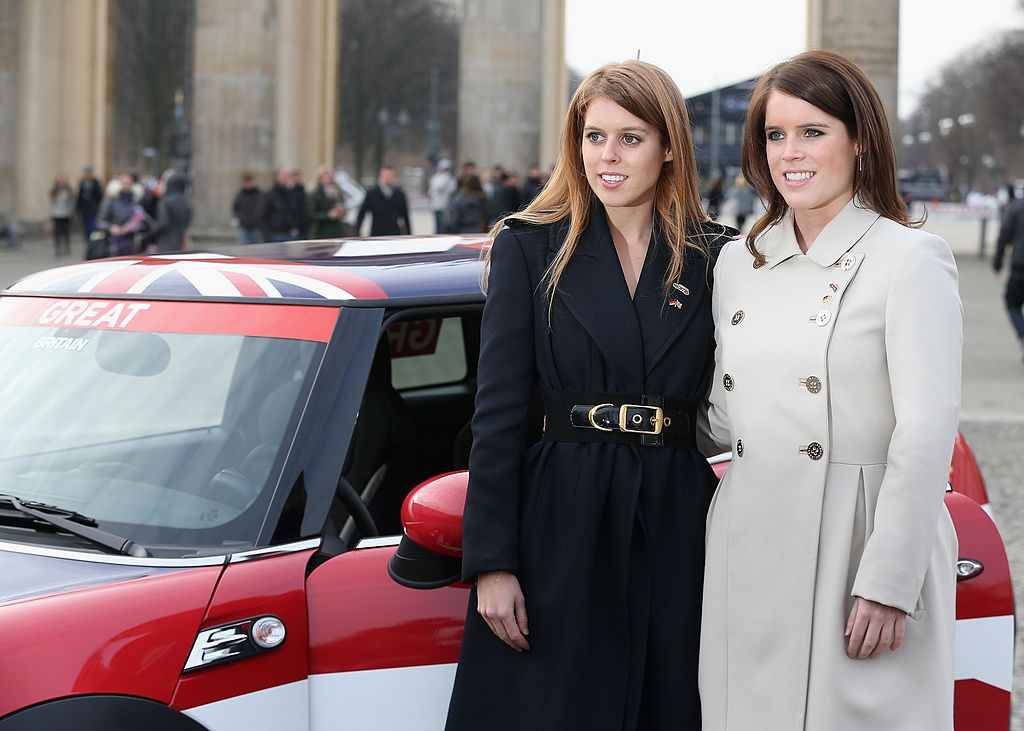  Princess Beatrice and Princess Eugenie pose next to a Mini in front of Brandenburg Gate on January 17, 2013 in Berlin, Germany. | Photo: Getty Images