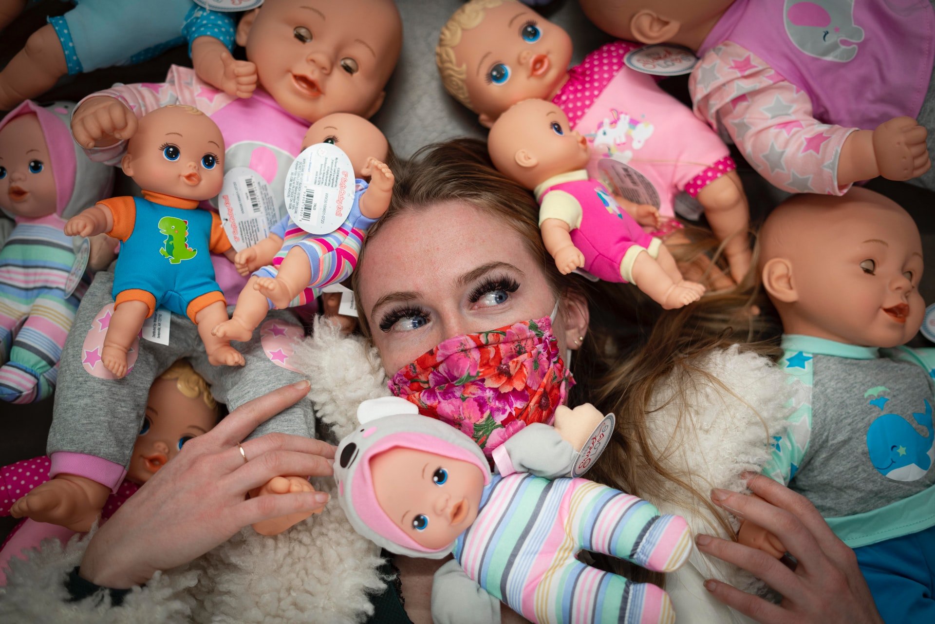 Joven rodeada de muñecas. | Foto: Unsplash