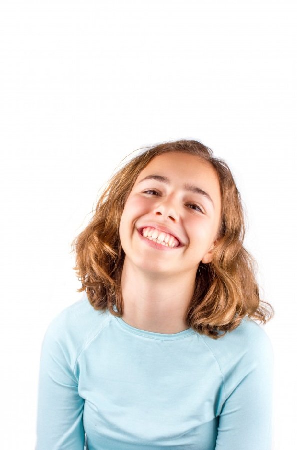 Niña mostrando una sonrisa traviesa. | Foto: Freepik