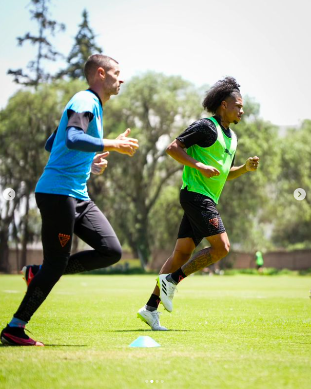 Marco Angulo and an unidentified man in the middle of what looked to be a training session. | Source: Instagram/ldu_oficial