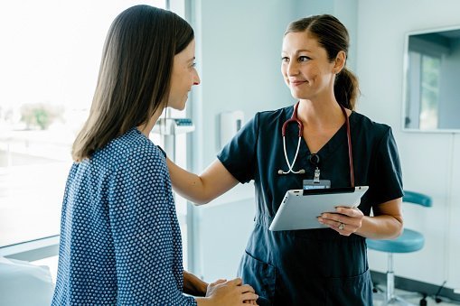 Female doctor consoling woman in a medical examination room | Photo: Getty Images