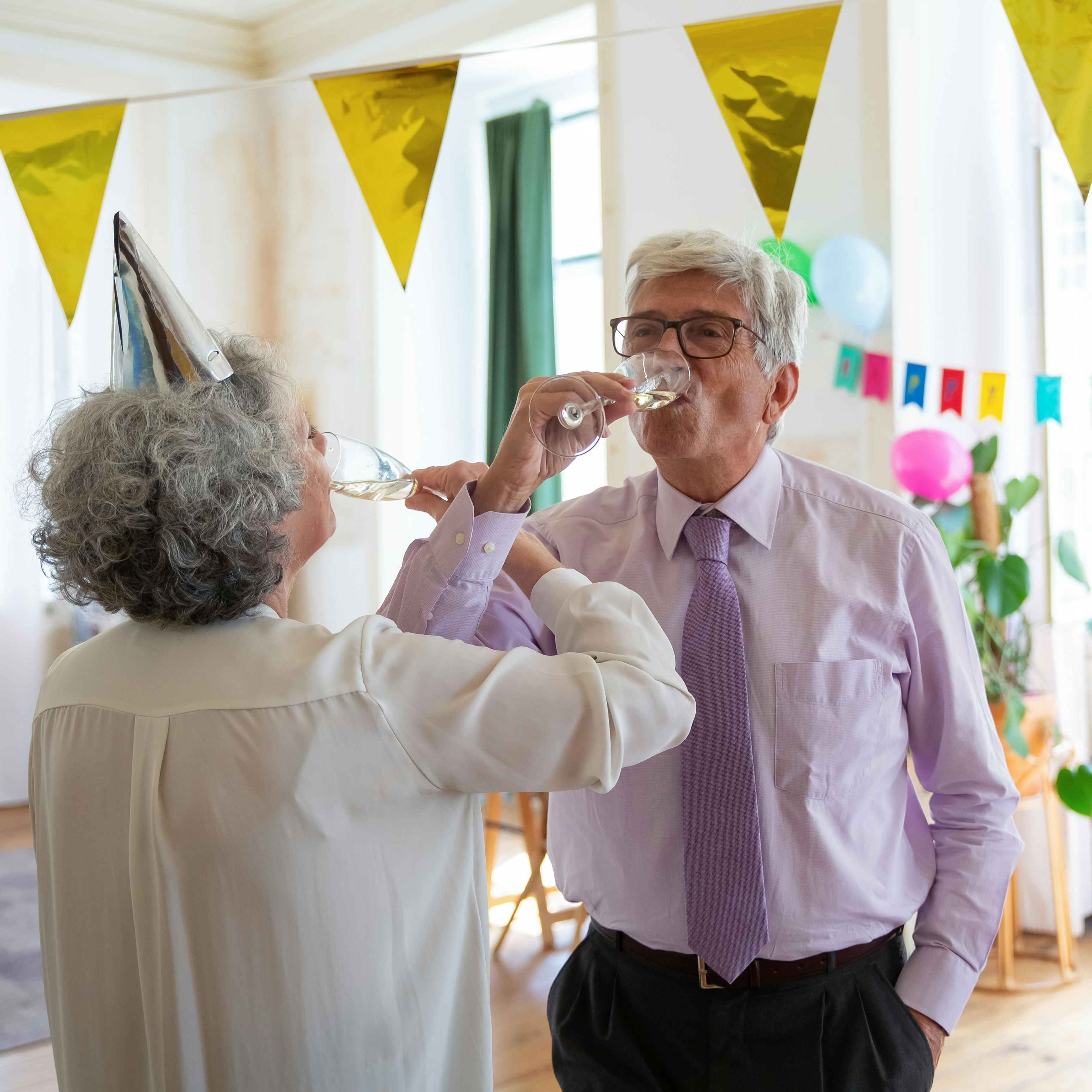 A man and woman sipping from champagne flutes | Source: Pexels