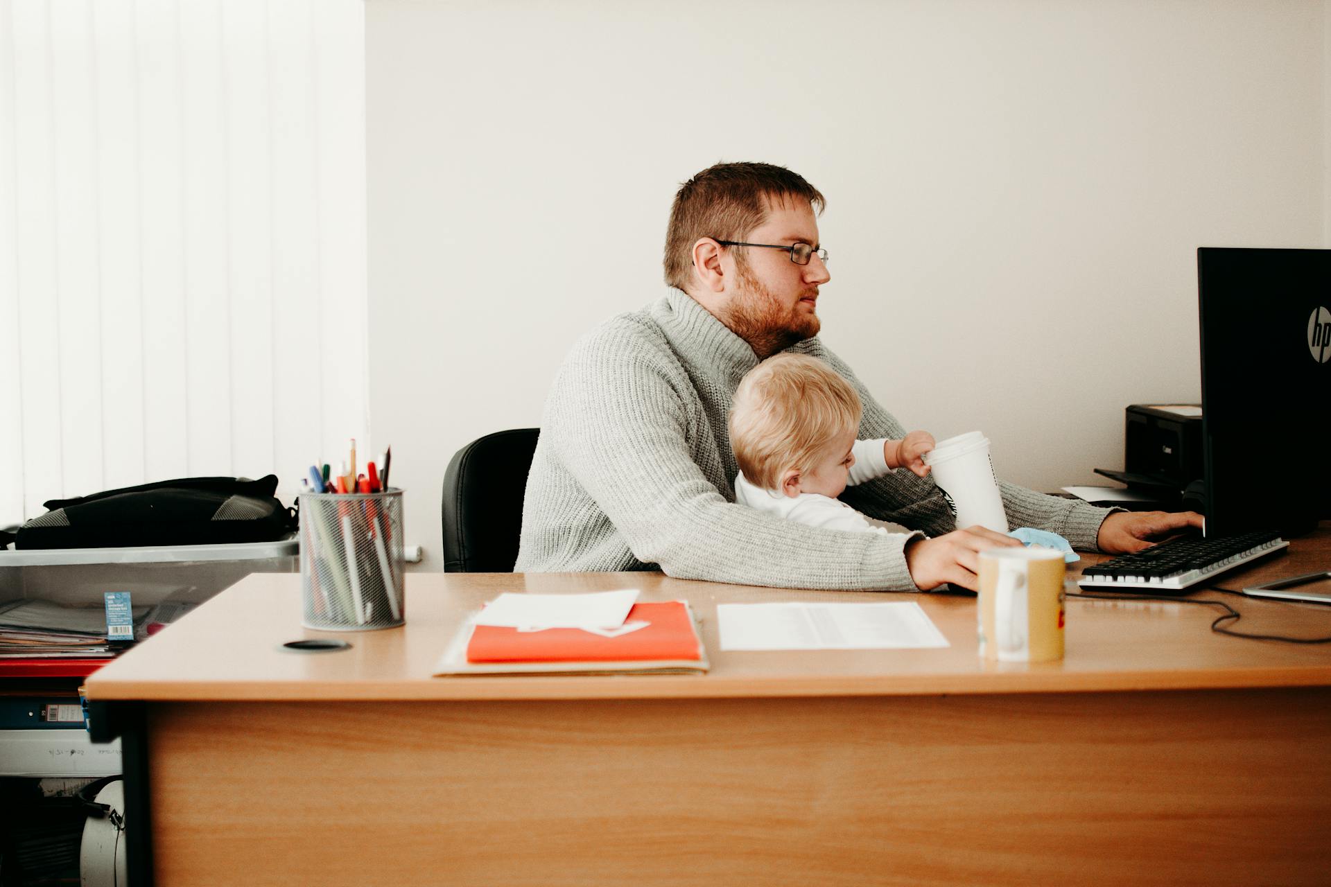 A man taking care of his son while working | Source: Pexels