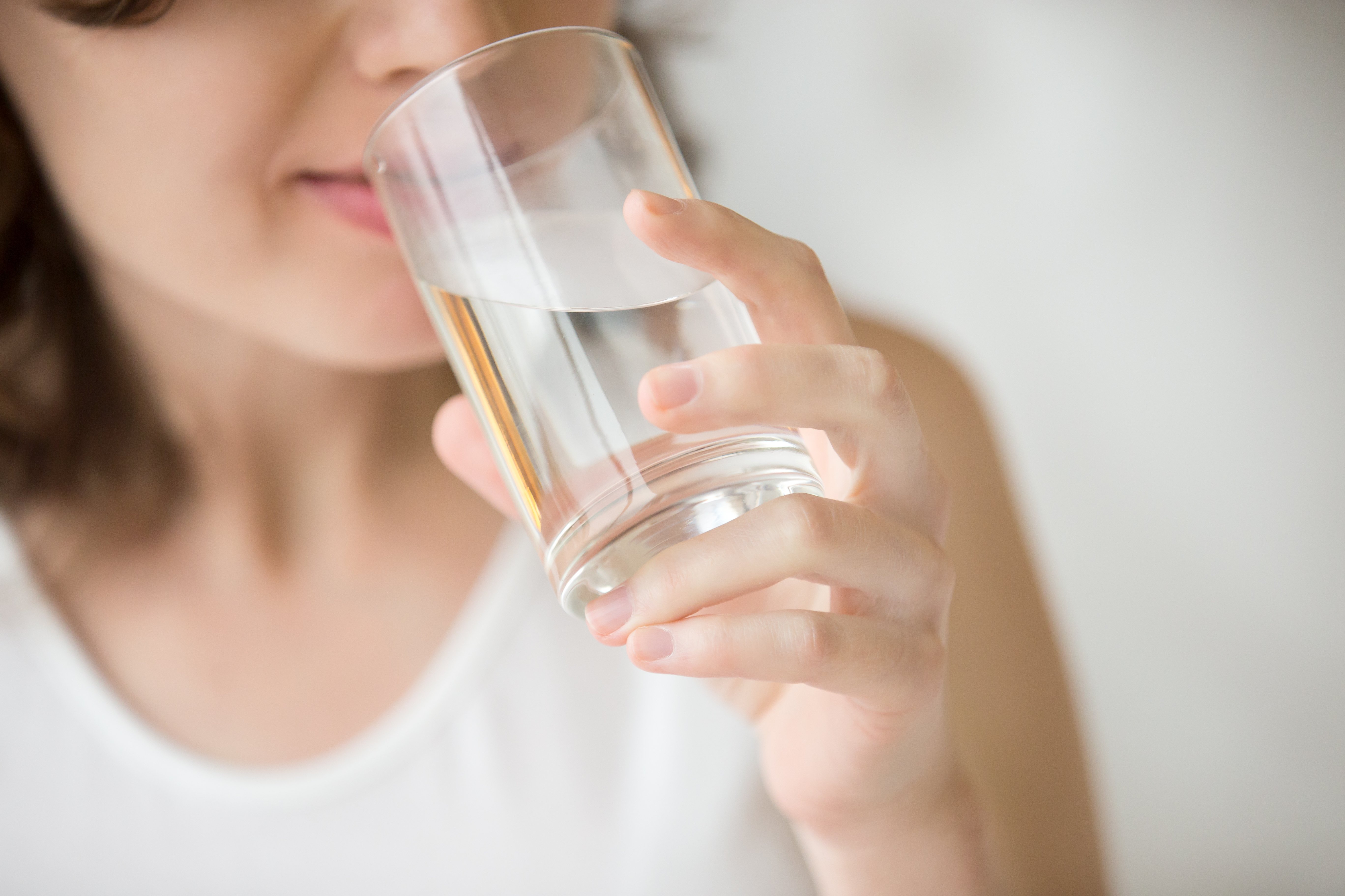 Une heureuse femme qui boit de l'eau. | Photo : Shutterstock