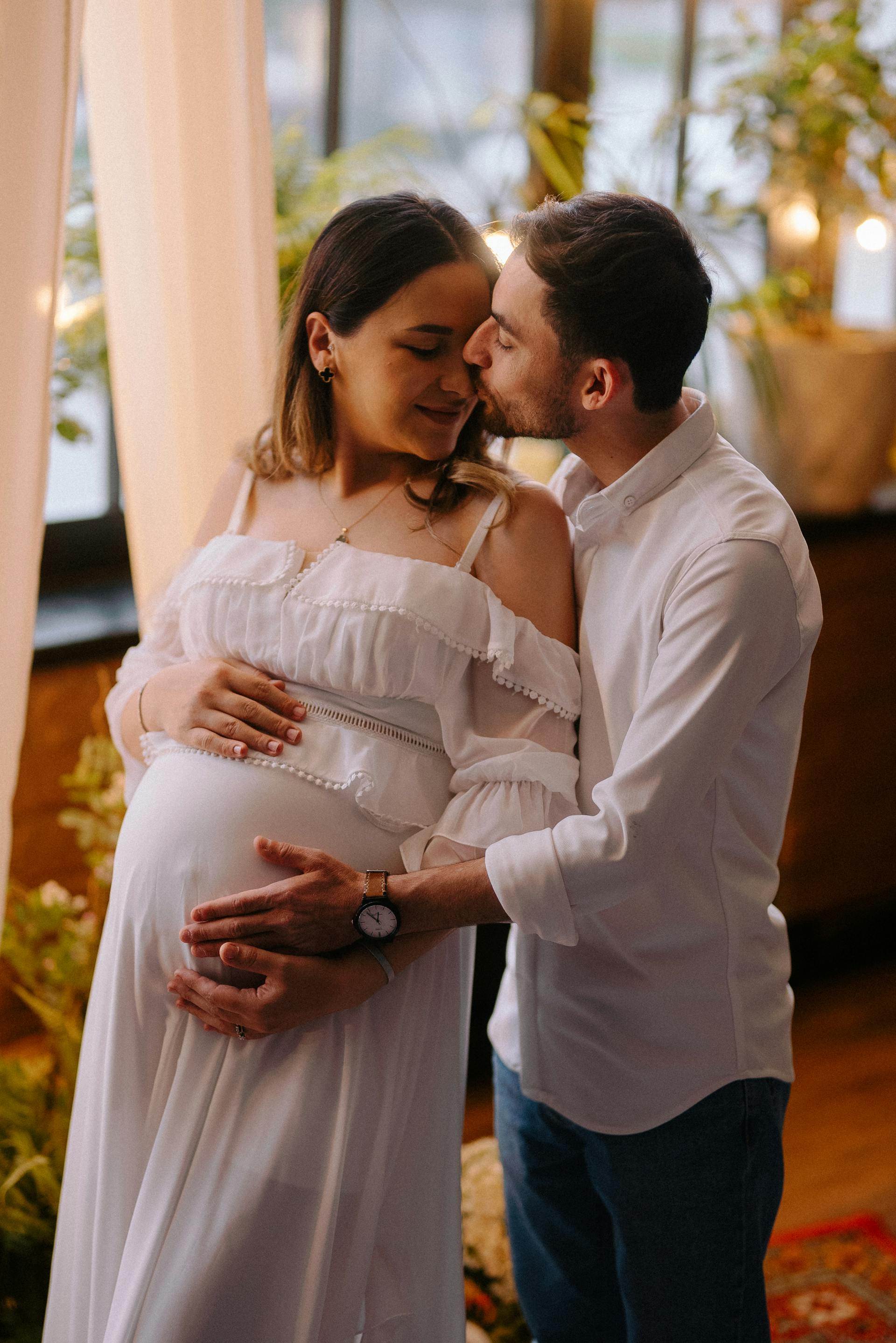 A man kissing and hugging his pregnant wife | Source: Pexels