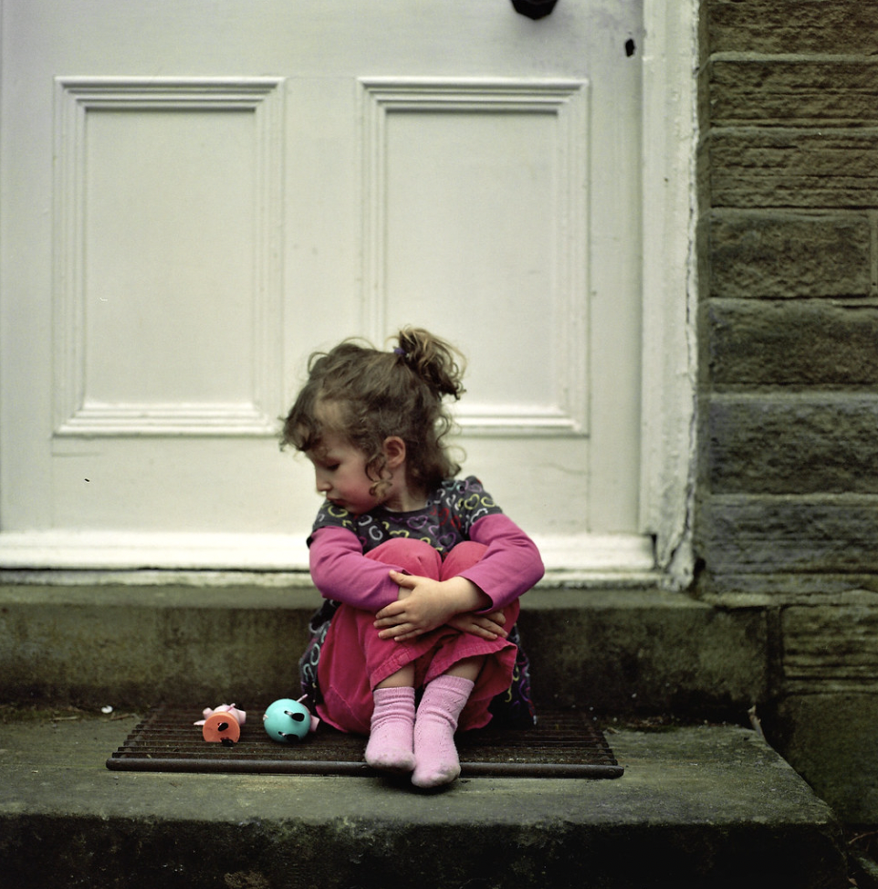 A girl sitting on the doorstep | Source: Shutterstock