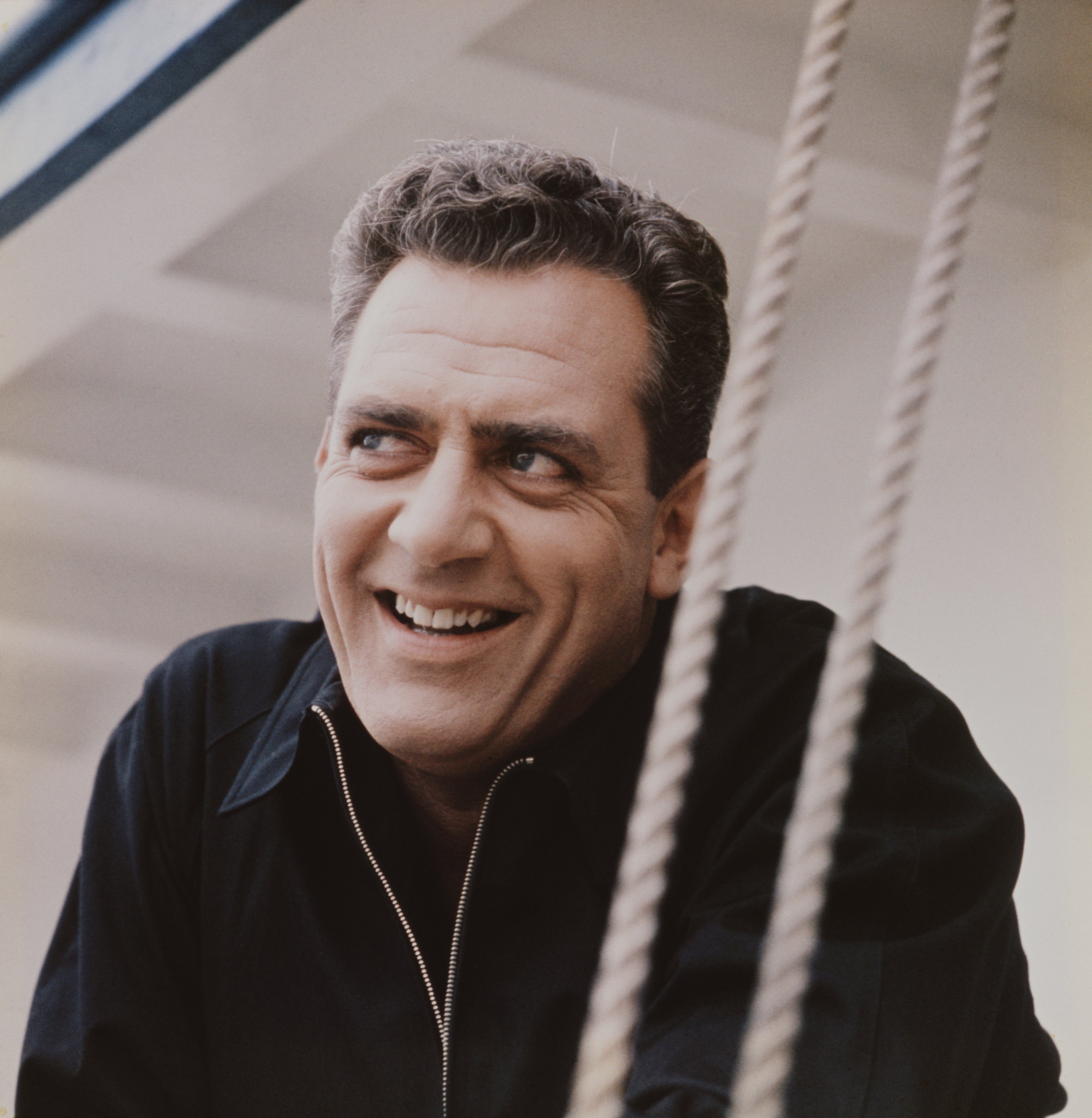 "Ironside" star Raymond Burr pictured smiling wearing a black jacket in 1962. / Source: Getty Images
