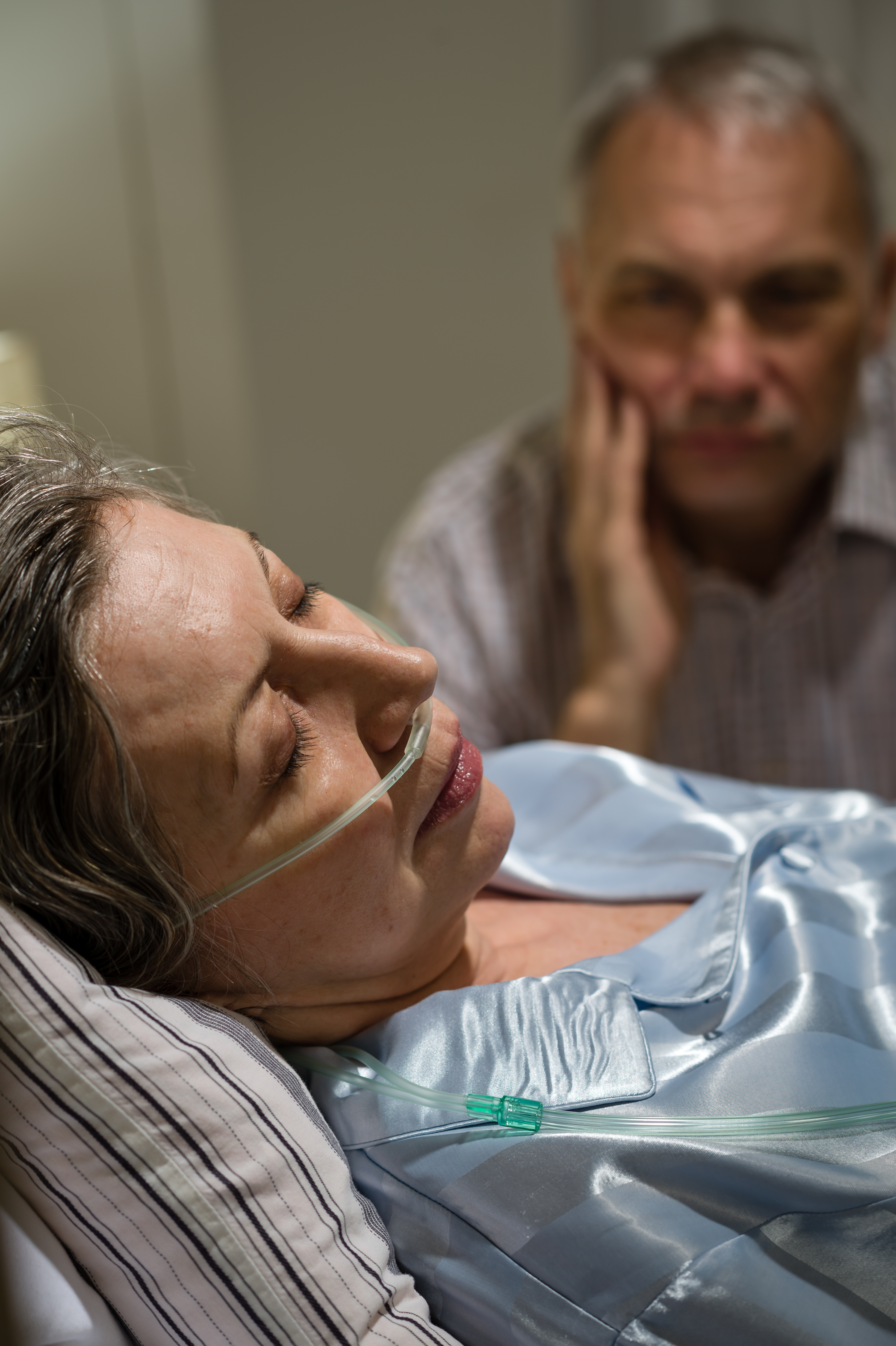 Ailing woman in hospital with a man beside her | Source: Shutterstock