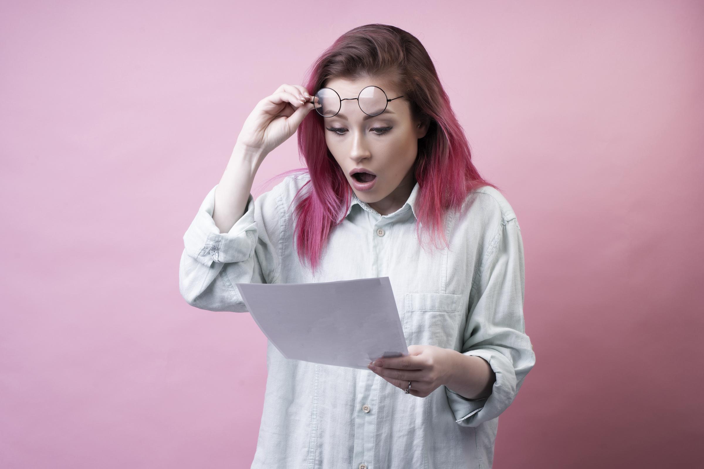 Shocked girl with glasses and paper | Source: Freepik