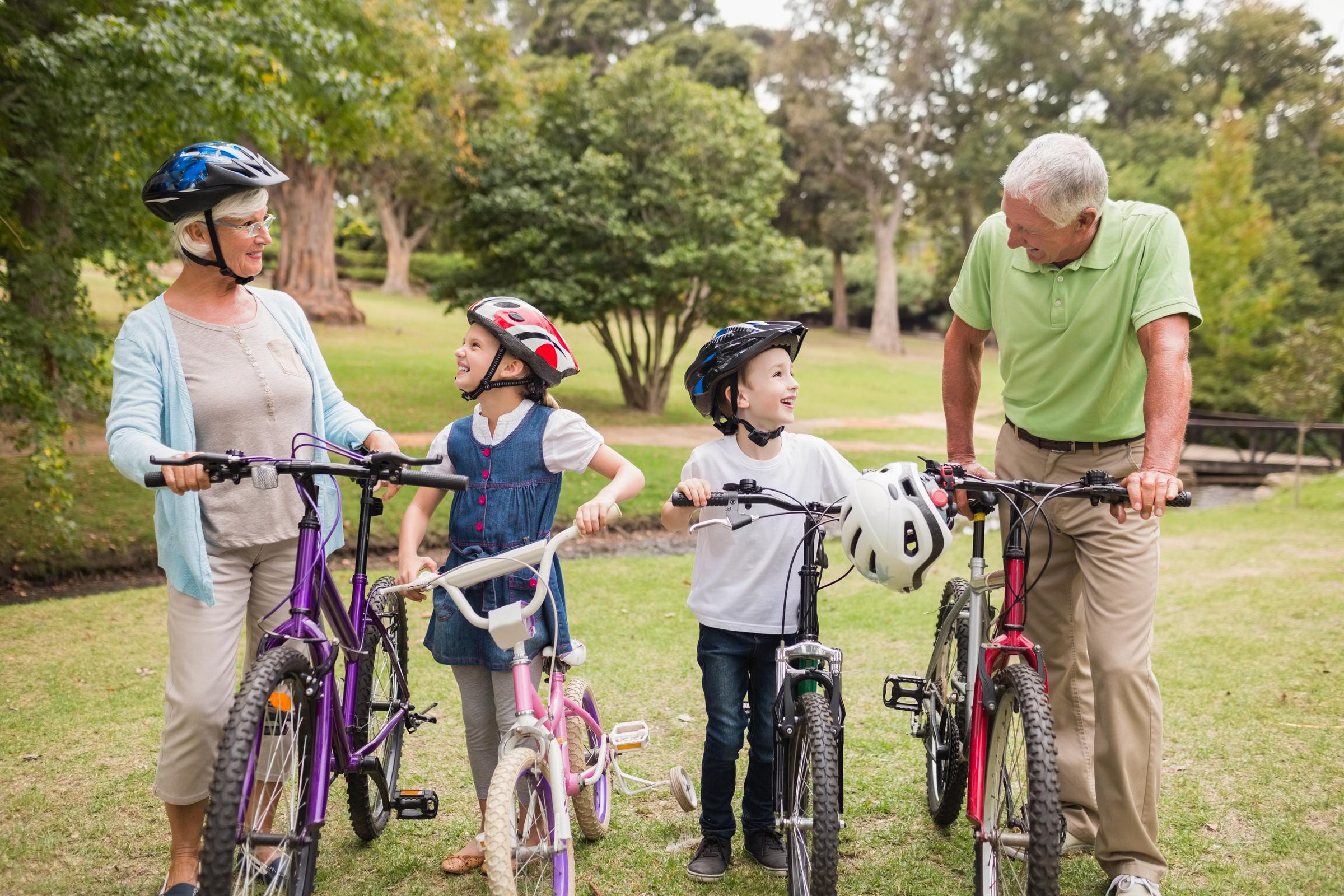 Grandparents and their grandchildren walking with their bikes | Source: Shutterstock