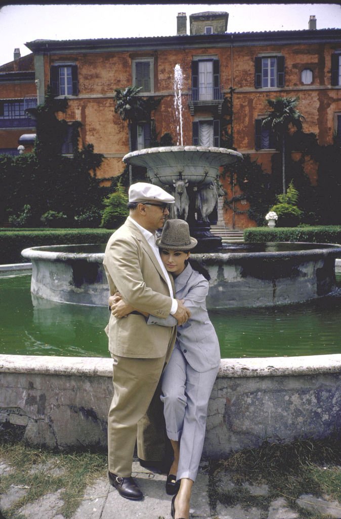 Sophia Loren et Carlo Ponti assis au bord d'une grande fontaine de leur villa. | Photo : Getty Images