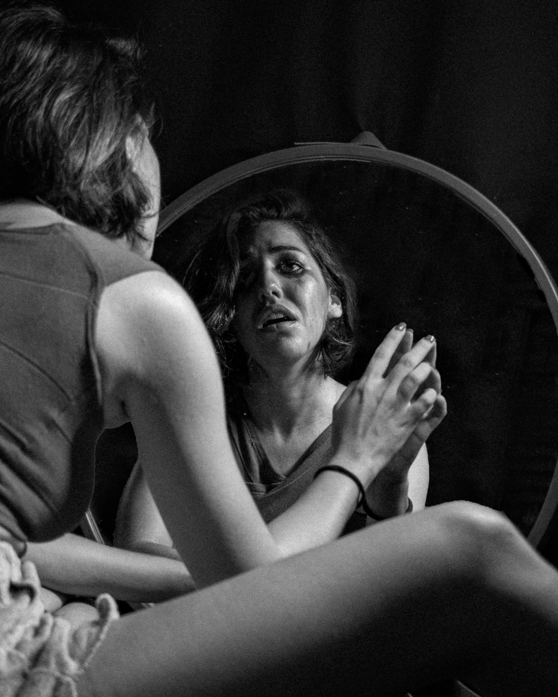 A grayscale photo of a crying woman looking in the mirror | Source: Pexels
