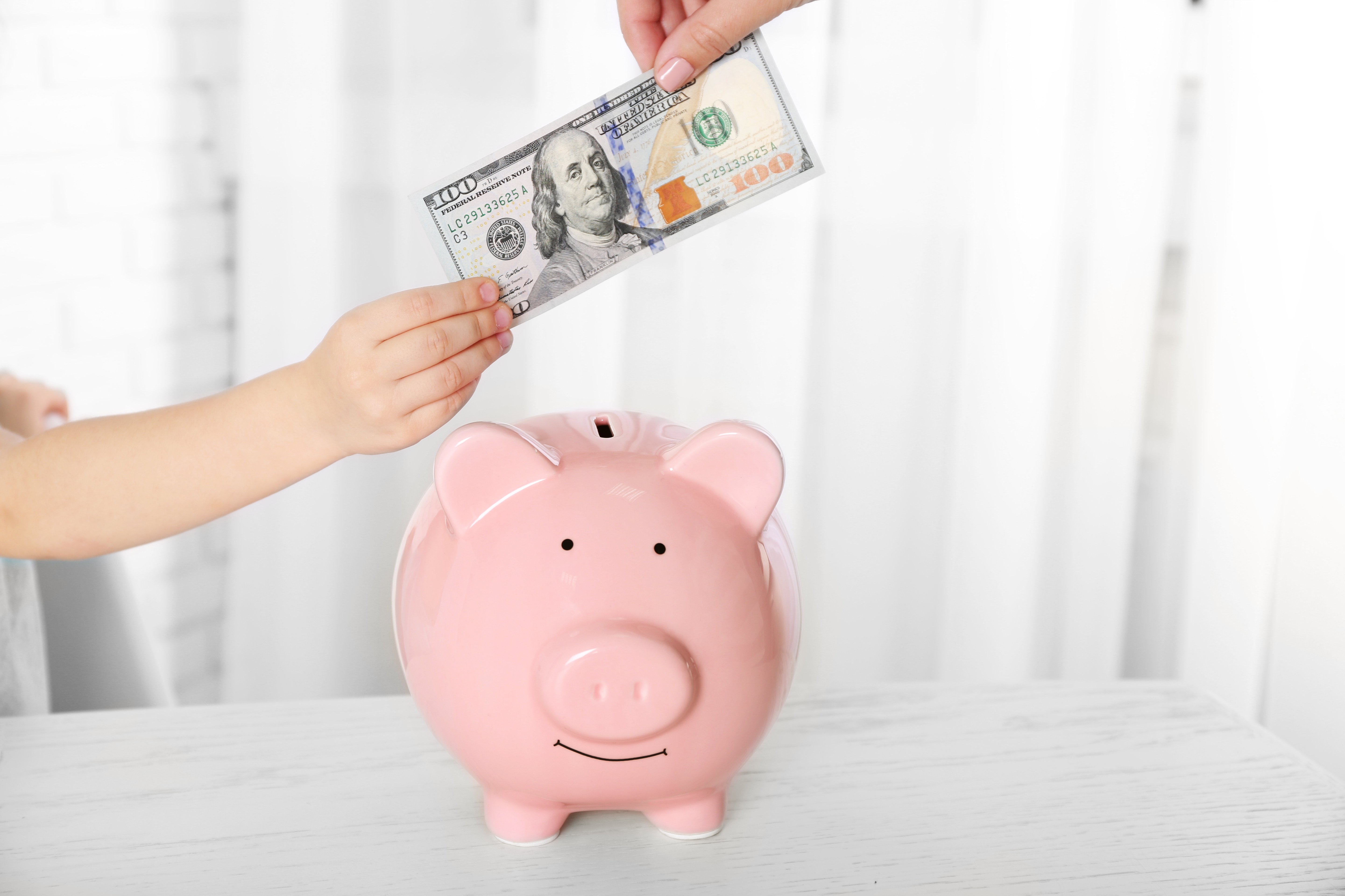 Madre tomando dinero de hija. | Foto: Shutterstock