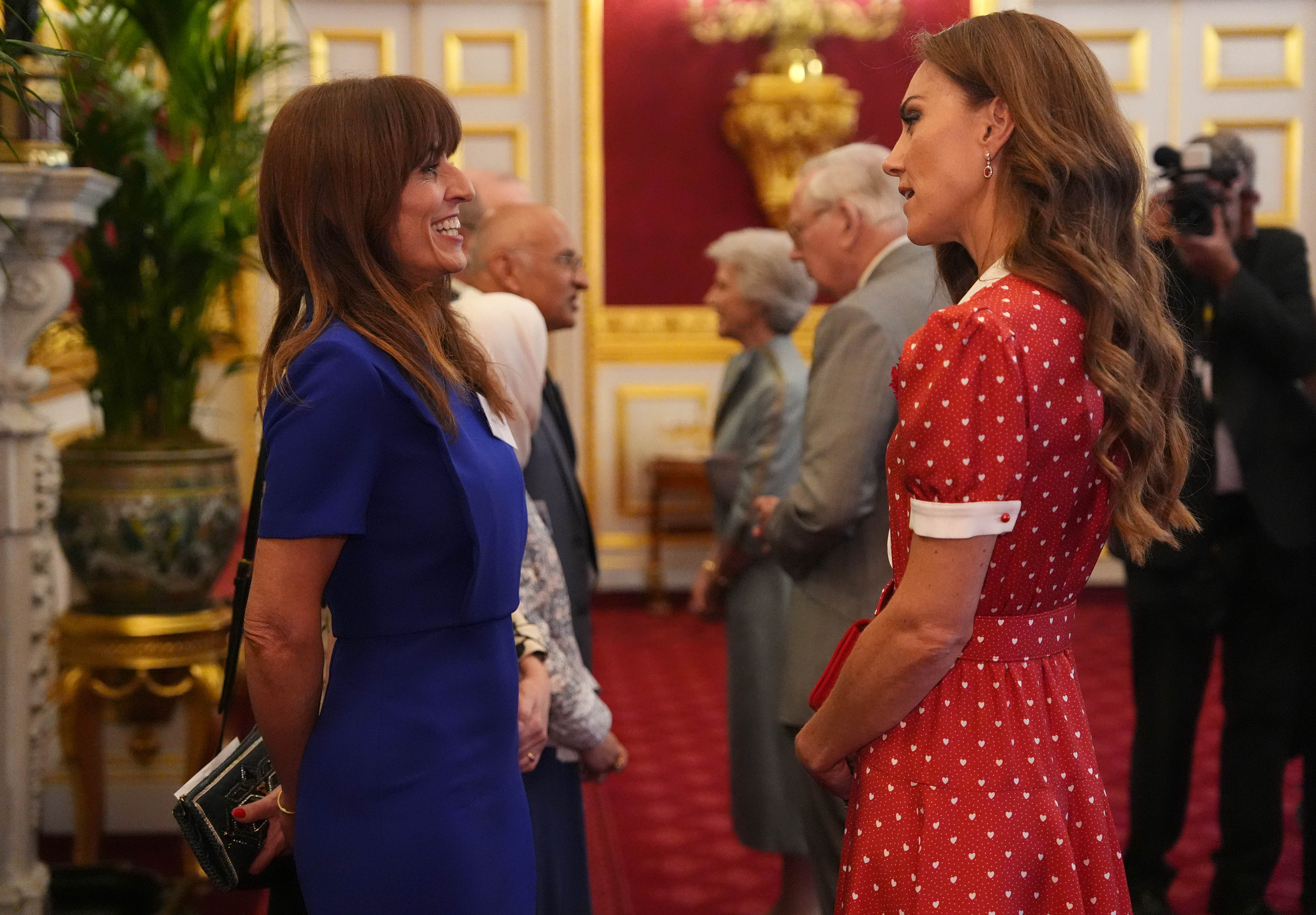 Kate Middleton shares an animated exchange with television presenter Davina McCall, effortlessly commanding the room as she helps celebrate a major milestone for one of the United Kingdom's leading cancer charities.