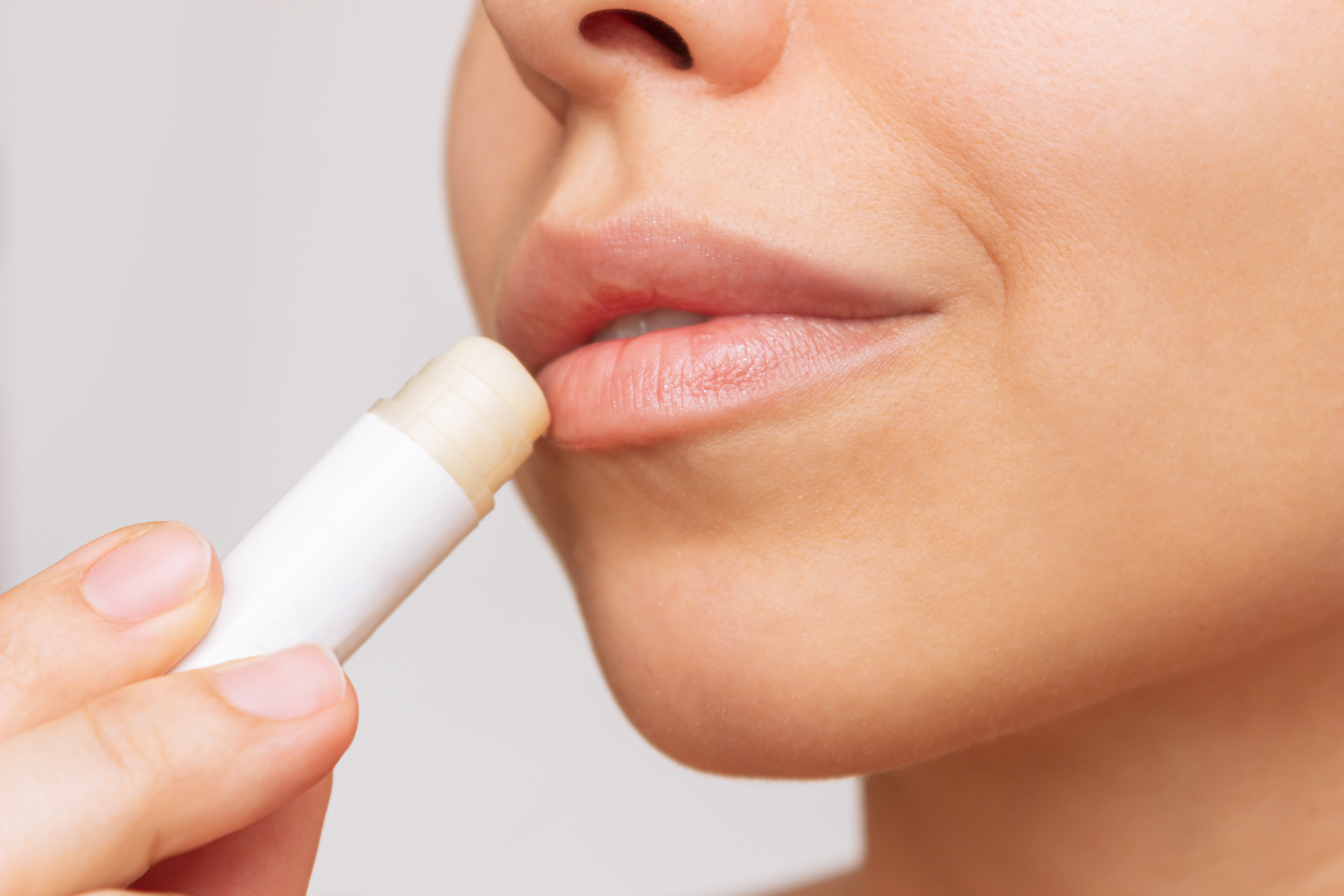 A close-up of a woman applying lip balm | Source: Getty Images