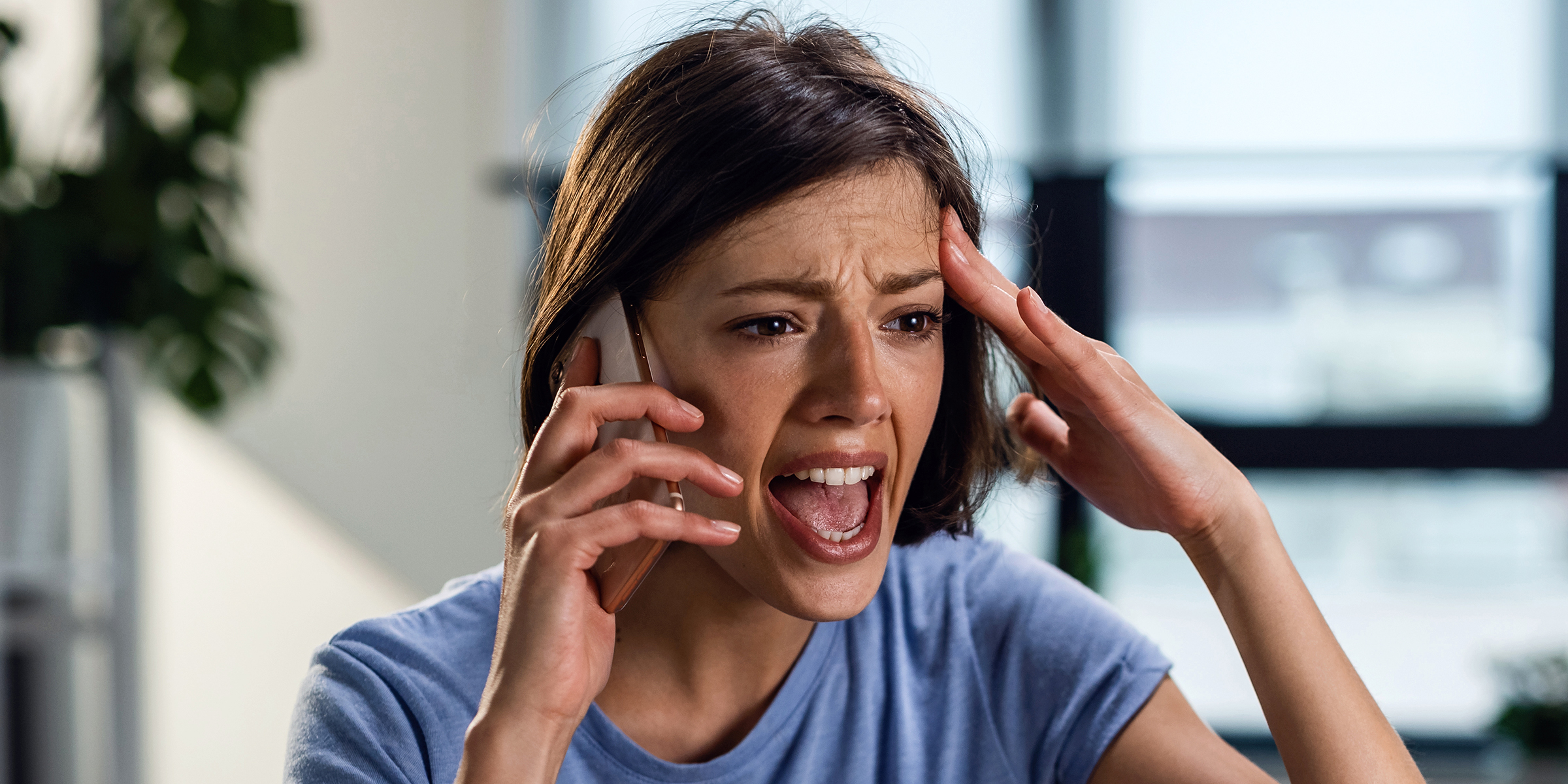 A shocked woman speaking on her phone | Source: Shutterstock